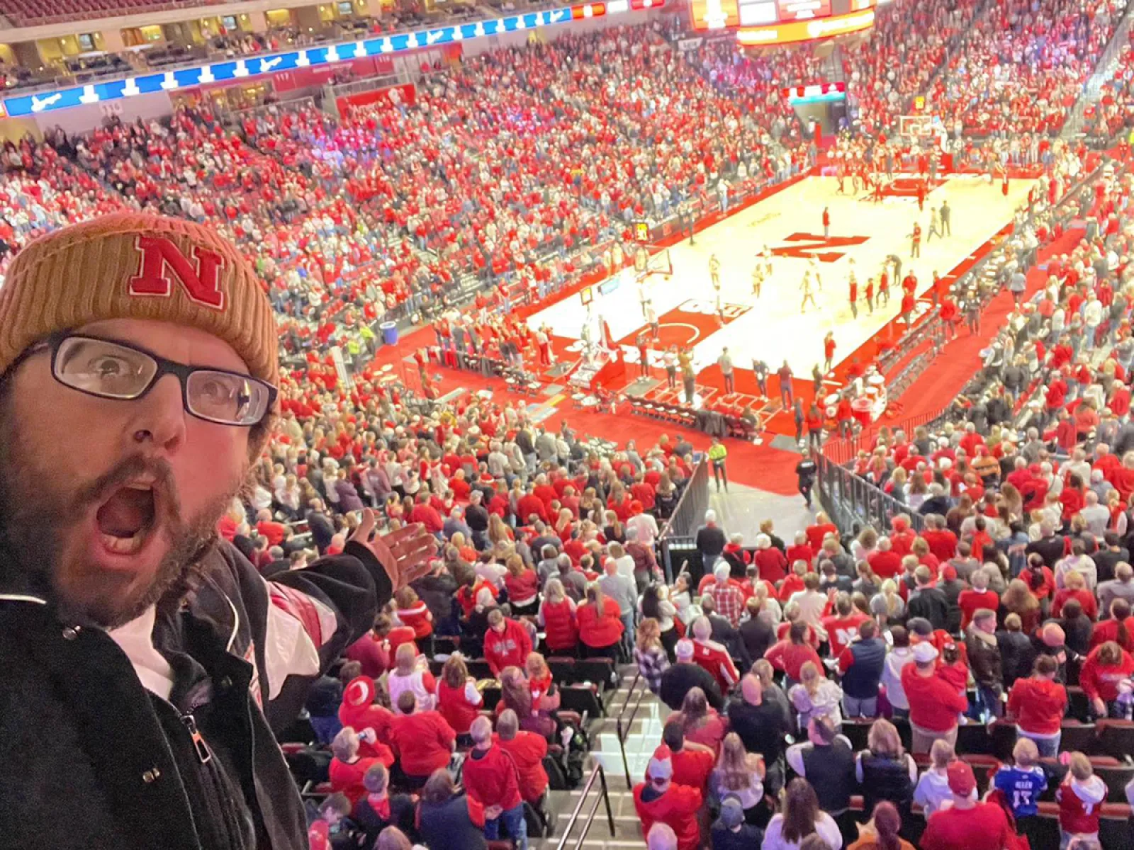 a person taking a selfie in a stadium full of people