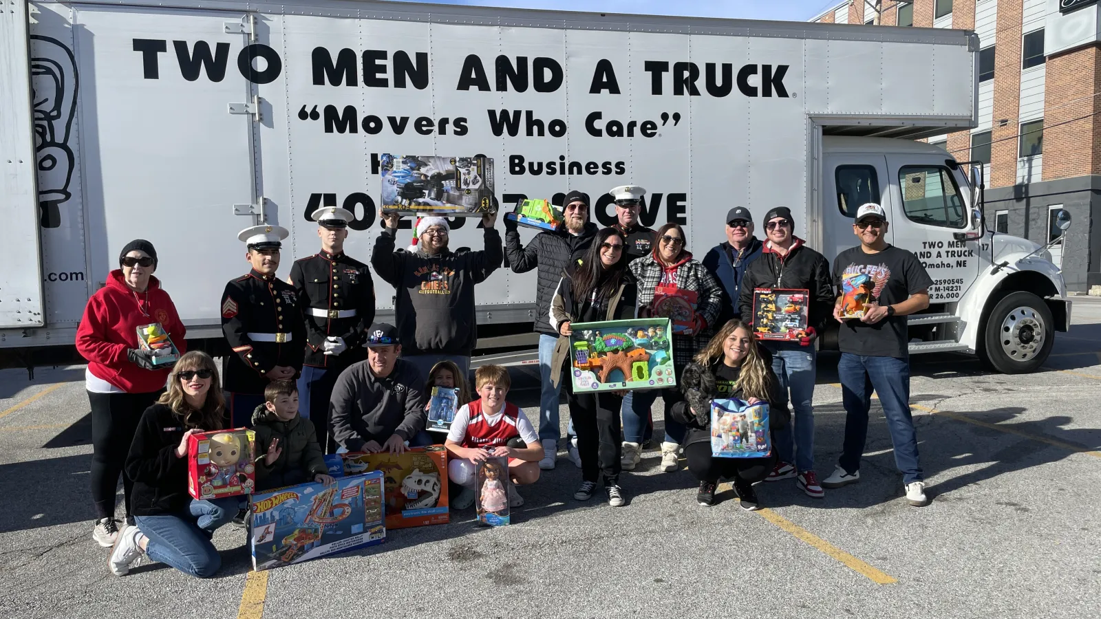 a group of people posing for a photo in front of a truck