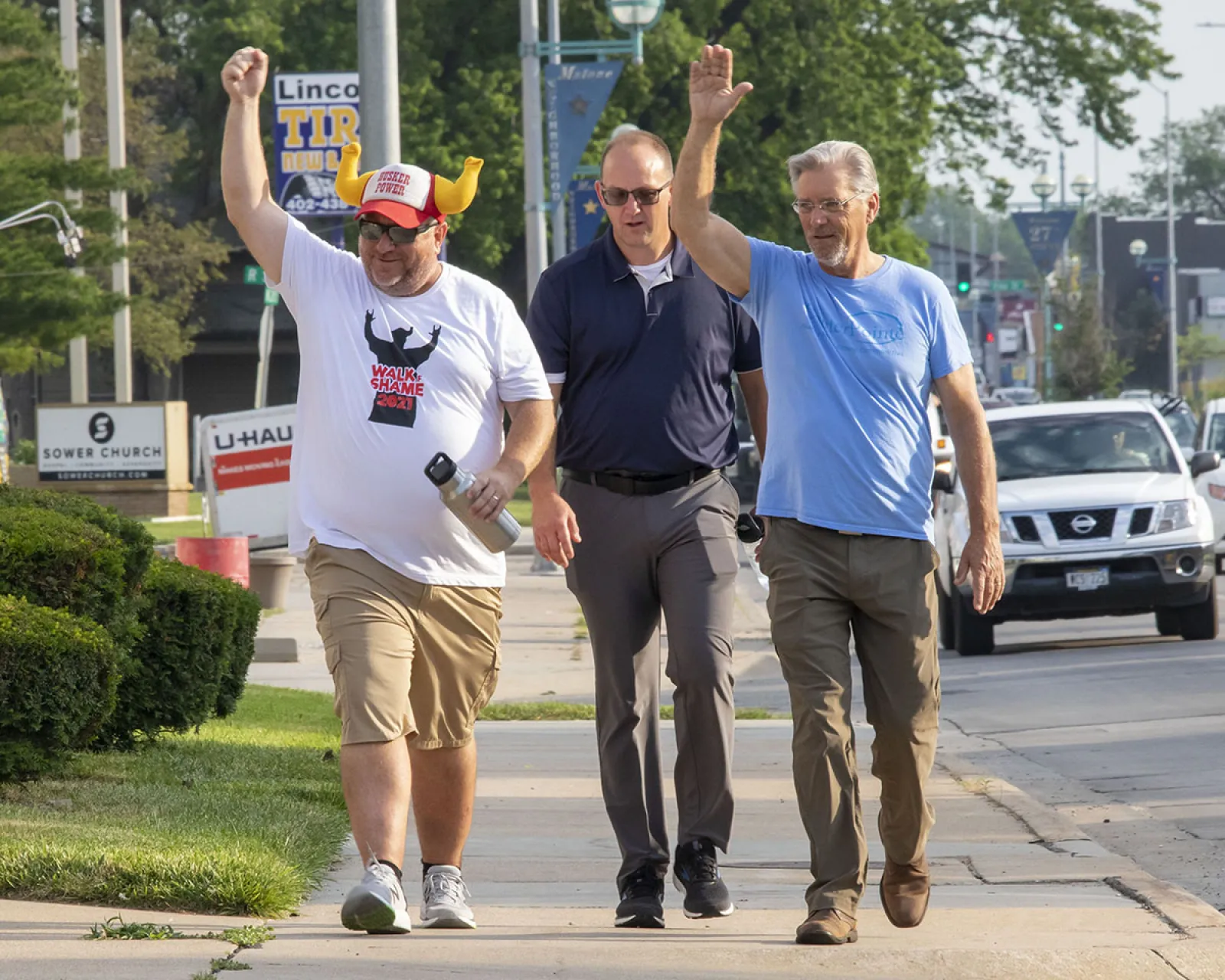 a group of men walking on the sidewalk