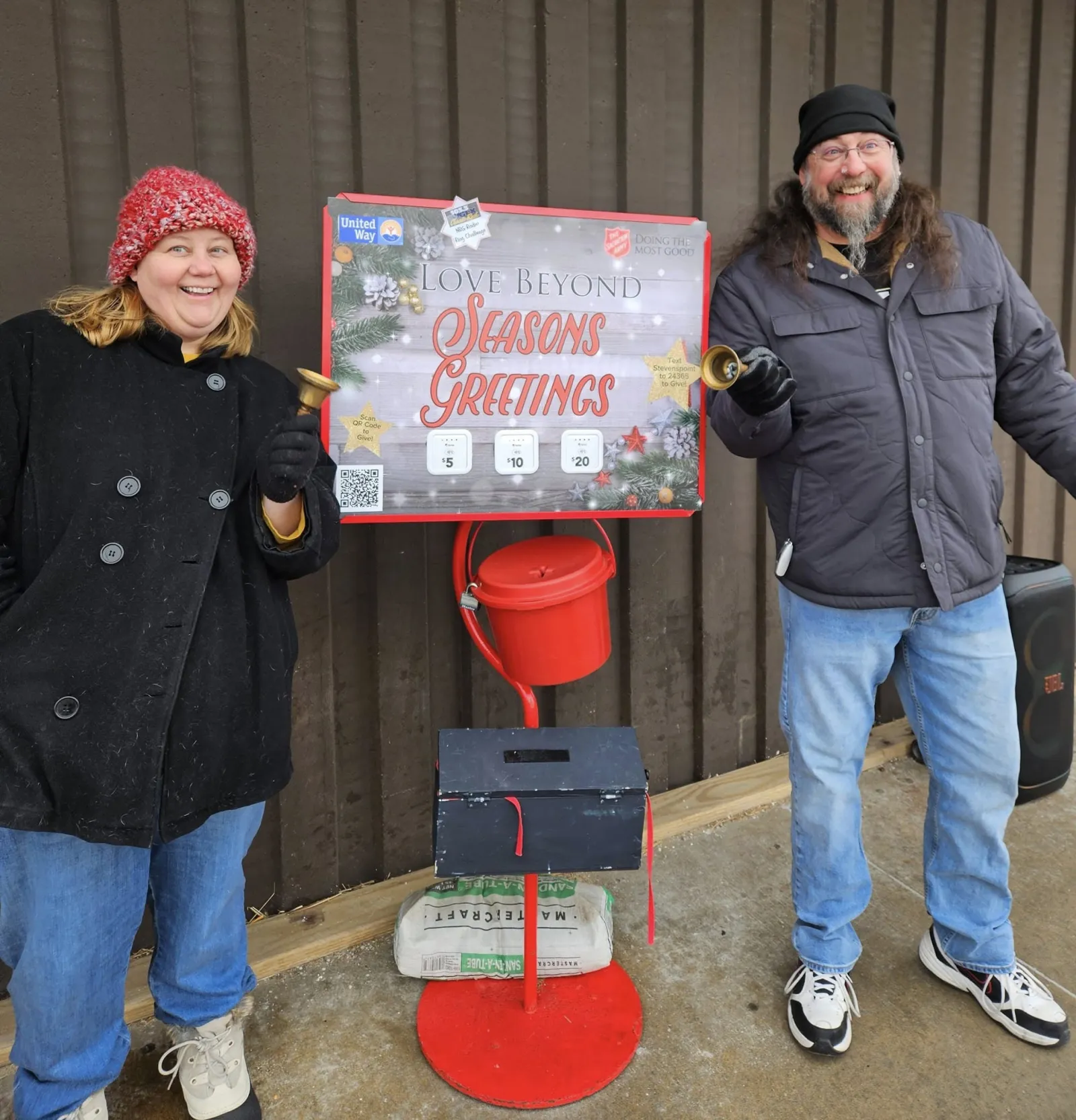 a man and woman standing next to a sign