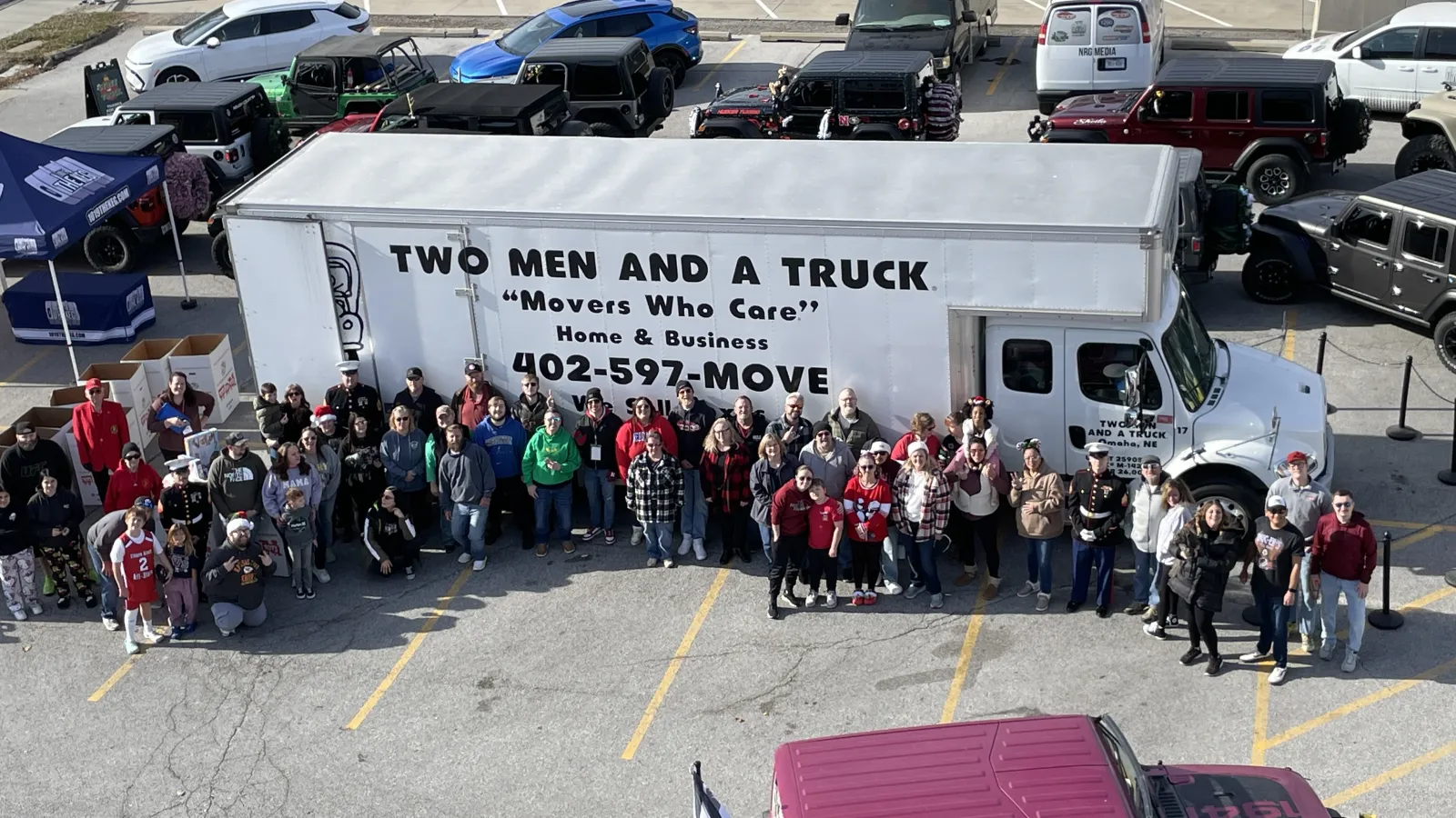 a group of people standing next to a large white truck