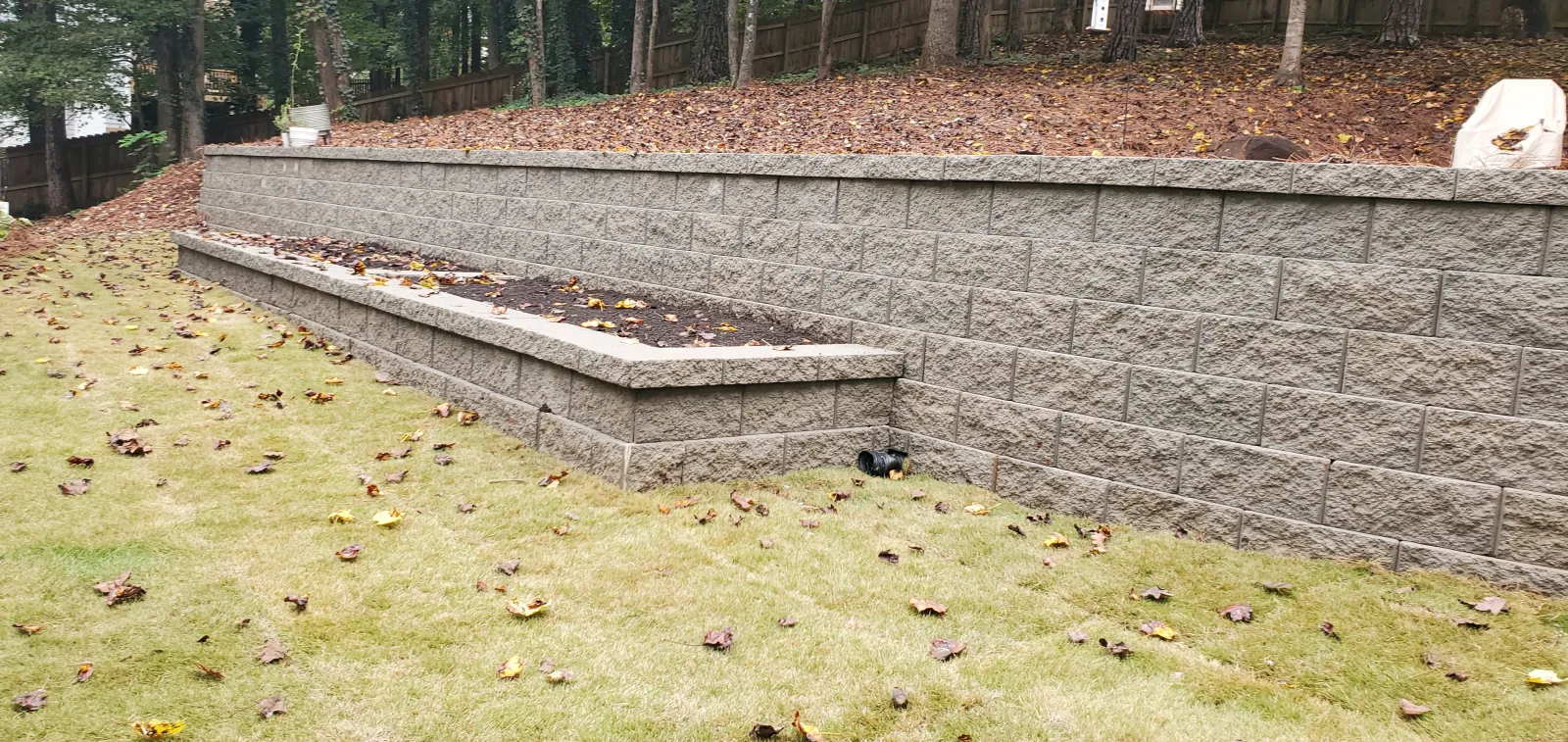 a stone wall with a bench and a stone wall