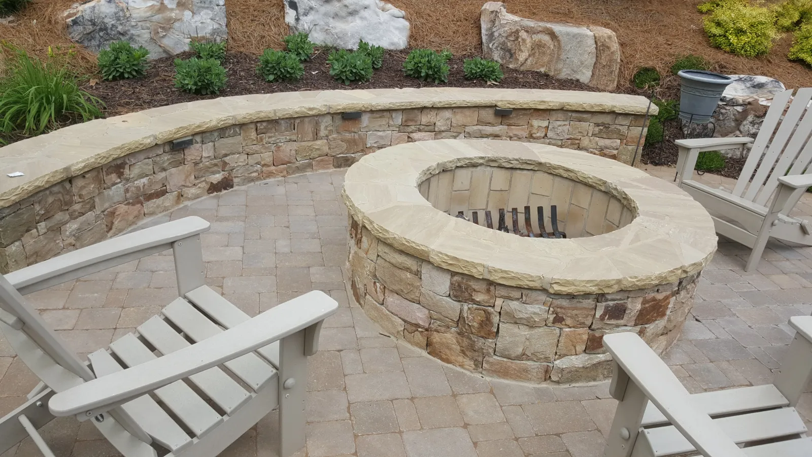 a stone fireplace with chairs around it