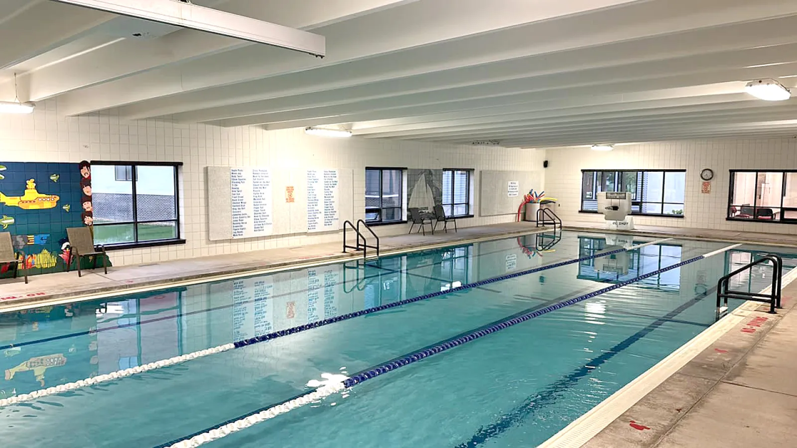 Indoor swimming pool with lanes, bright lighting, and a clean environment for recreational use.