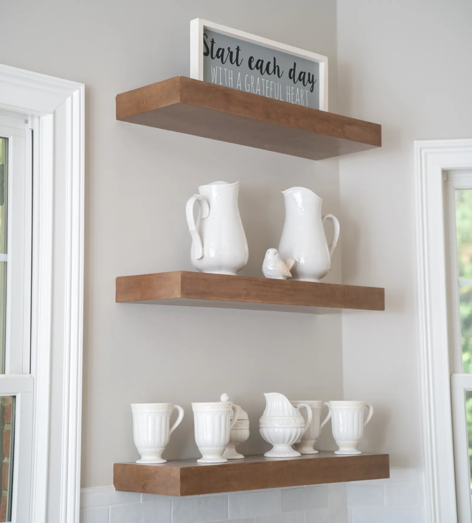 a shelf with white vases and cups on it