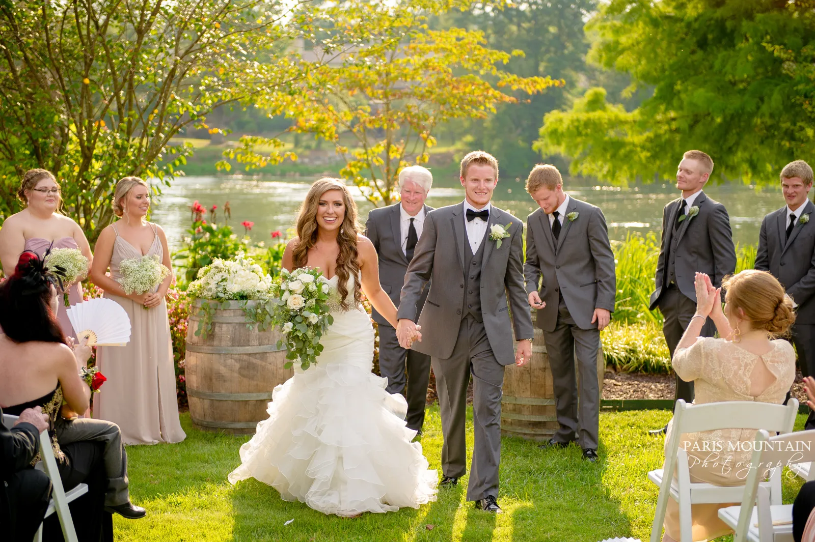 a group of people standing in front of a wedding cake