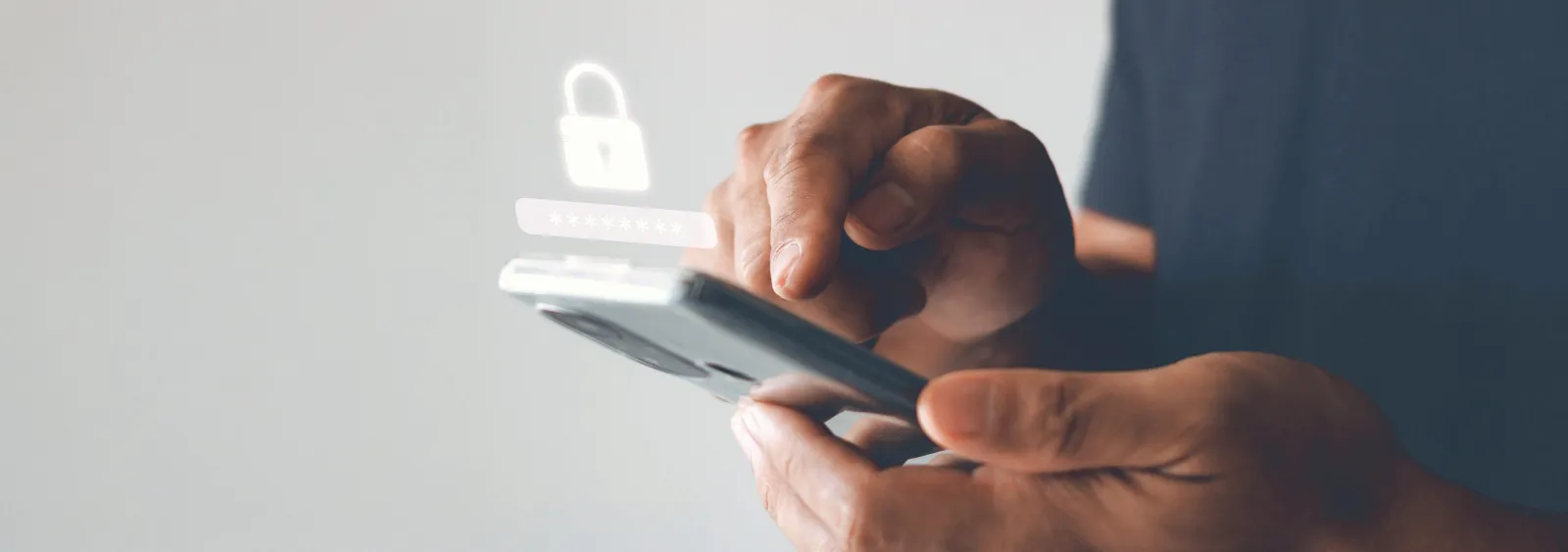 Close-up of hands using a smartphone with a digital security lock icon displayed.