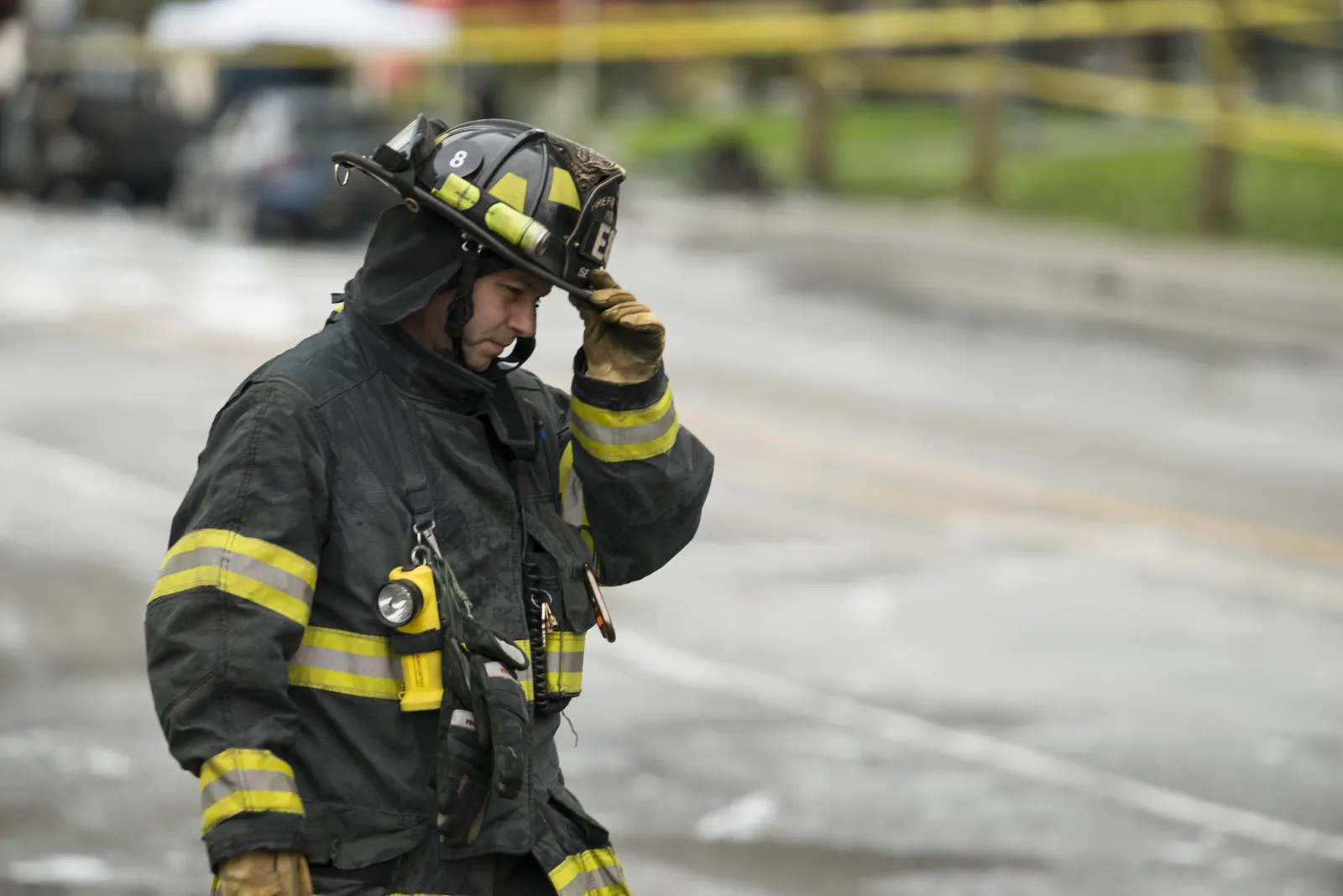 A fireman walks through an accident scene on the side of a roadway.