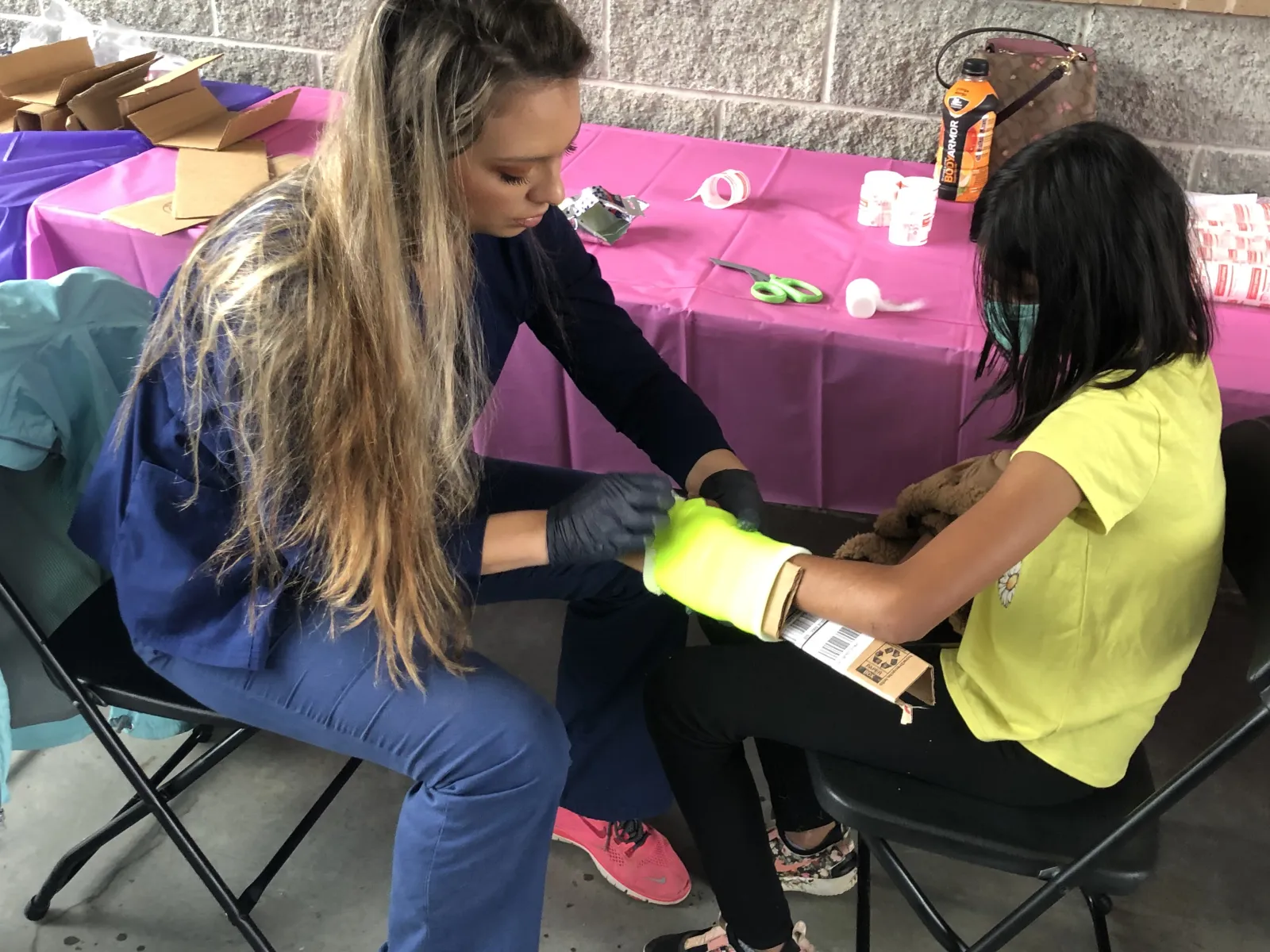 Taylor Brown, a medical assistant, puts a cast on a young female patient.