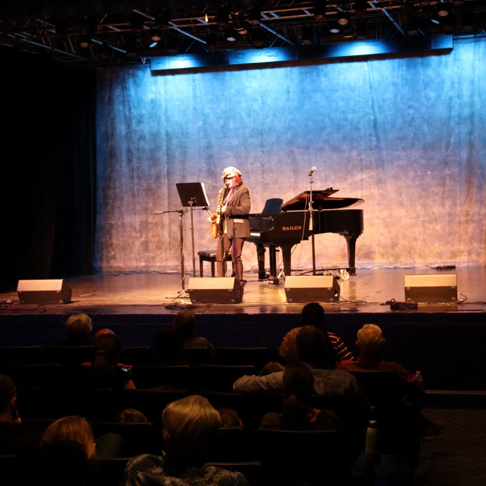 a person playing a piano on a stage in front of an audience