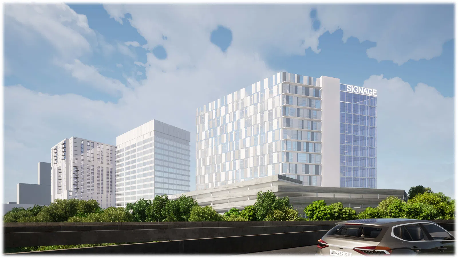 Modern office buildings with reflective glass windows behind green trees under a blue sky with clouds