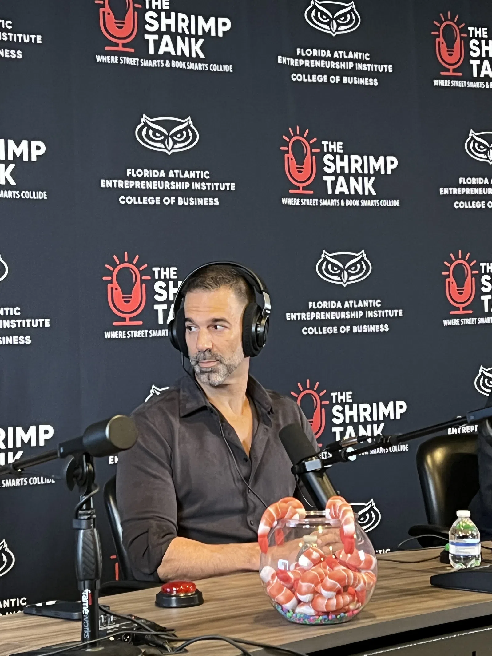 Man wearing headphones speaking into microphone during The Shrimp Tank podcast at Florida Atlantic Entrepreneurship Institute