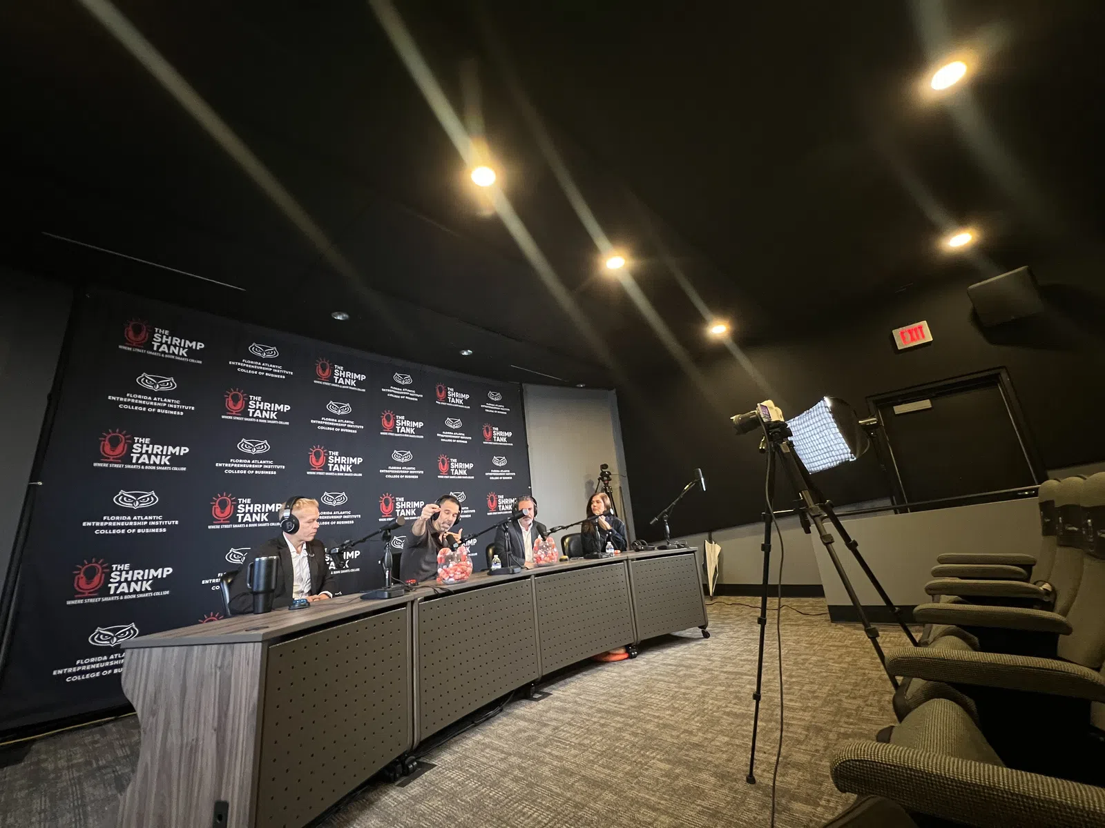 Panel of four judges at The Shrimp Tank event seated at a desk with microphones in a conference room.
