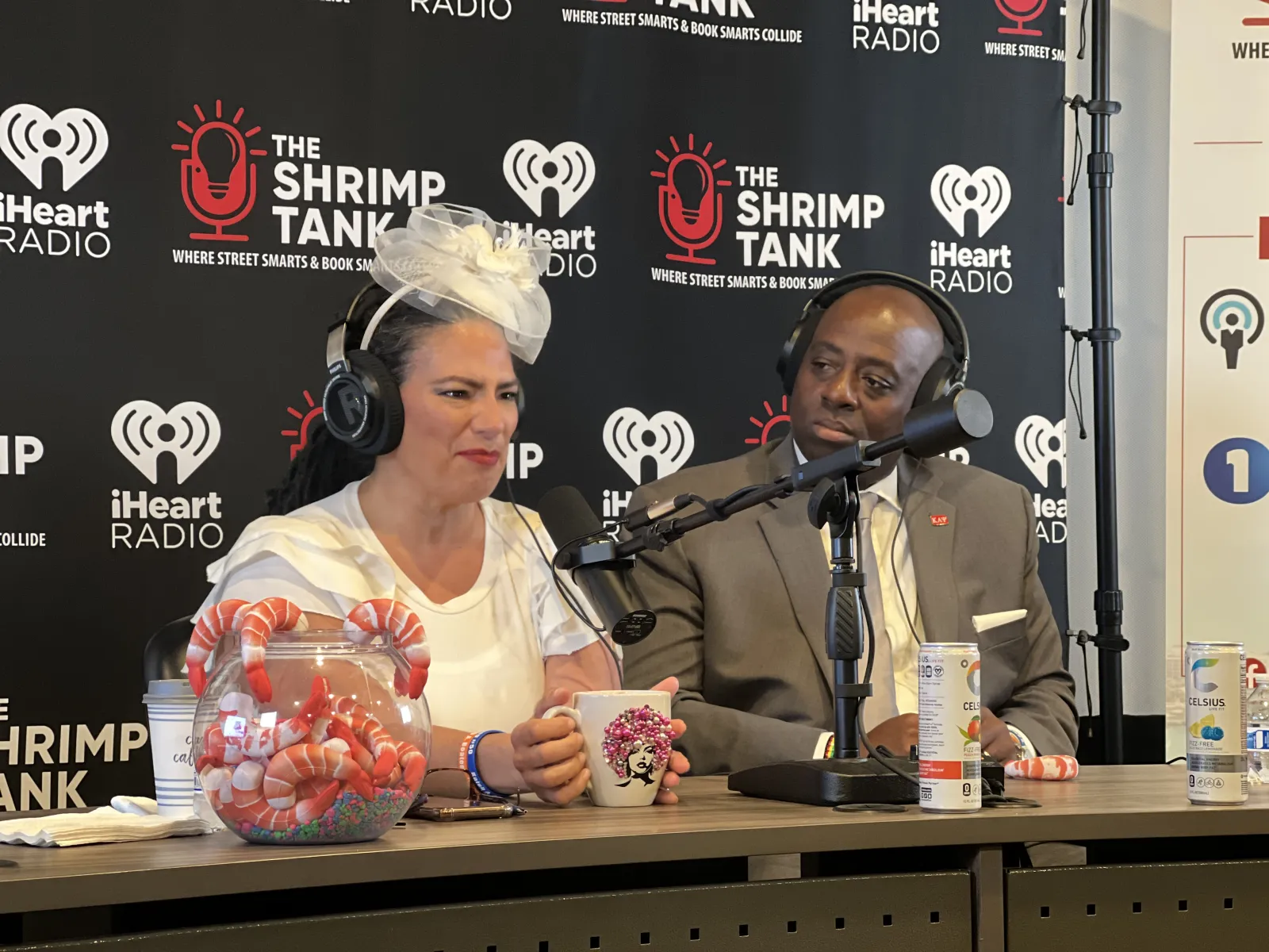 a man and woman sitting at a table with microphones