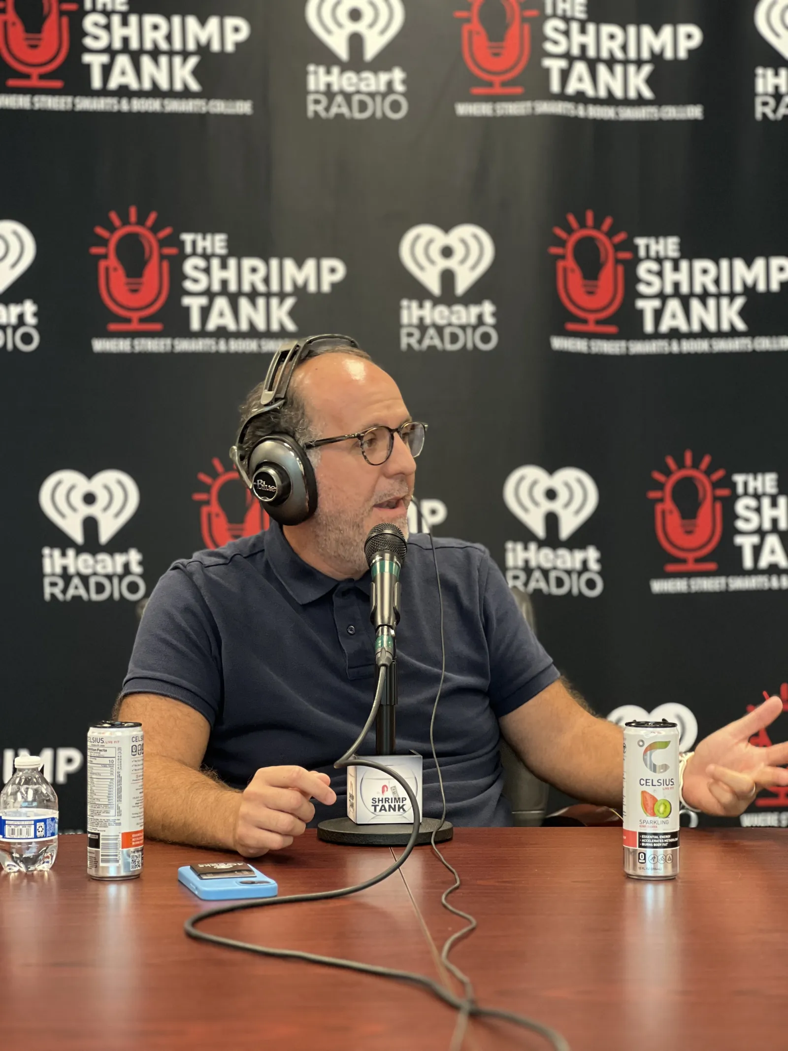 a man wearing headphones and sitting at a table with a microphone