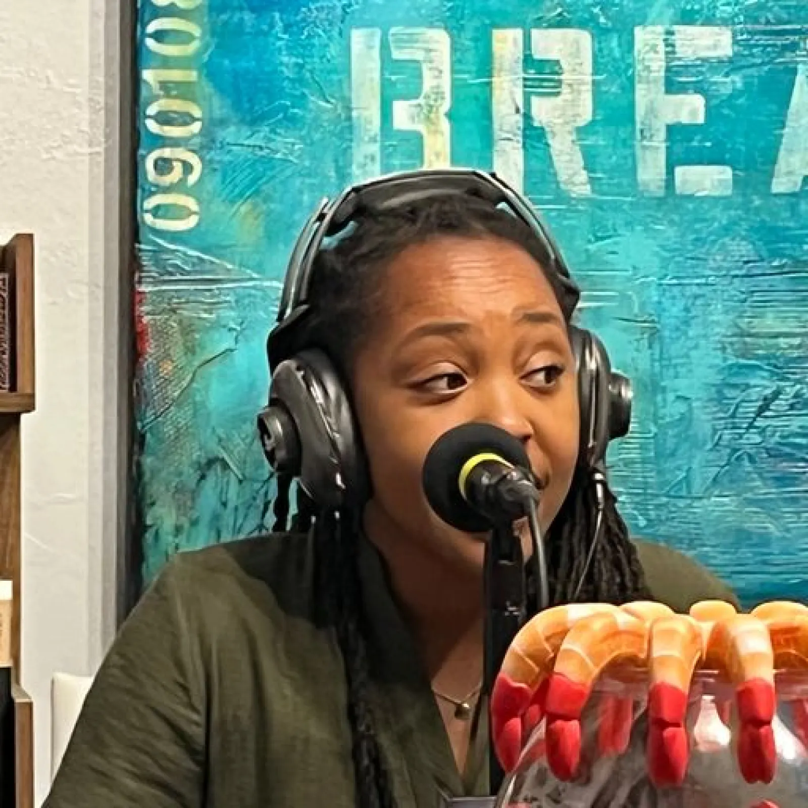 a woman wearing headphones and holding a hot dog