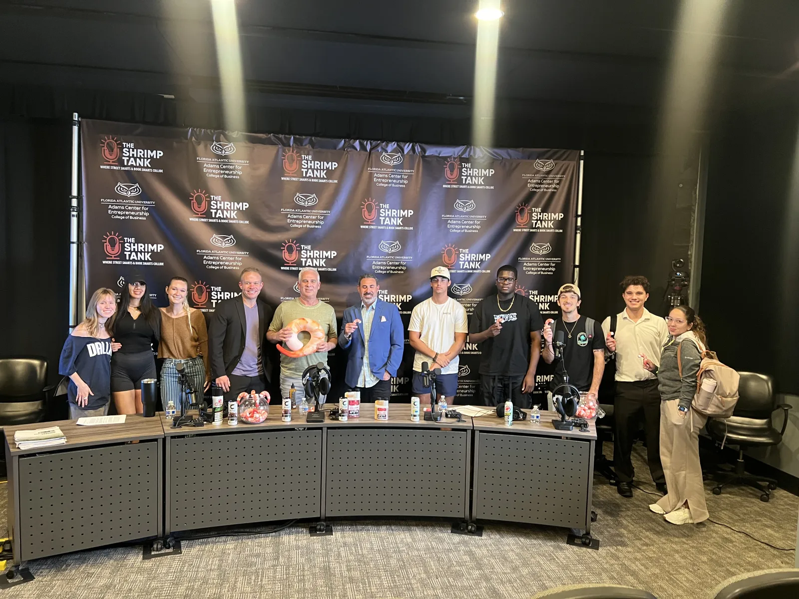 a group of people standing in front of a table with drinks