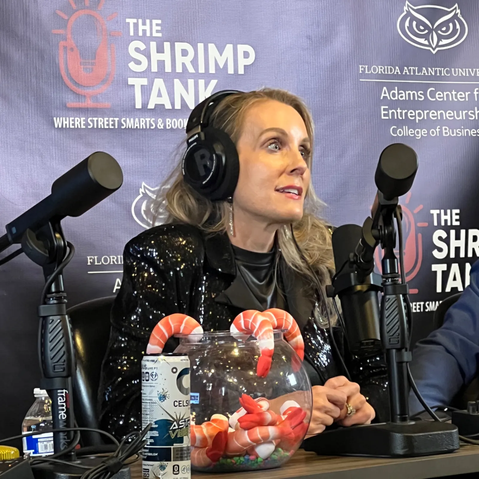 Woman with headphones speaking into microphone during The Shrimp Tank podcast at Florida Atlantic University