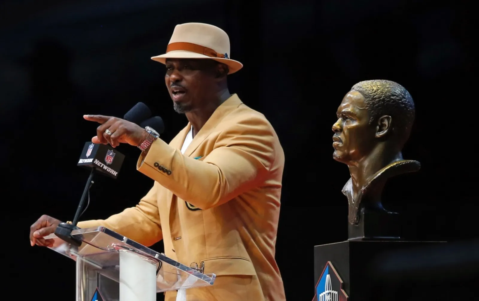 Brian Dawkins with a microphone pointing at another man