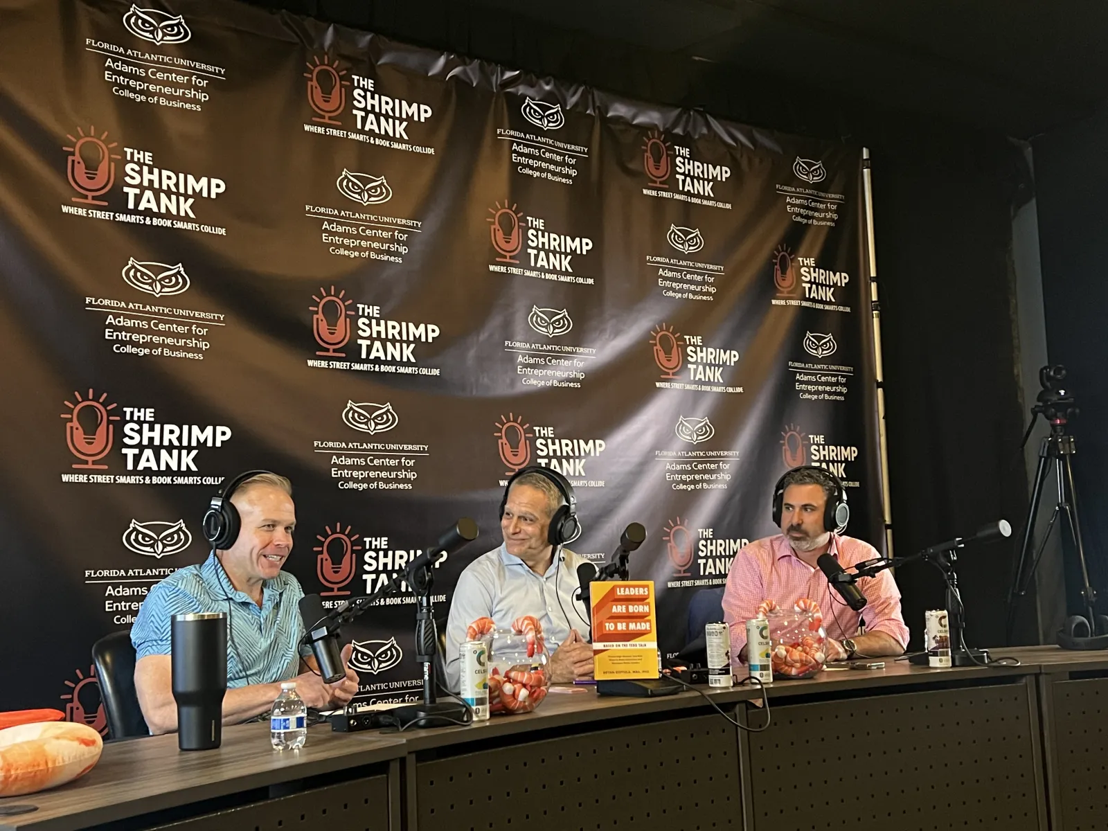 a group of people sitting at a table with microphones