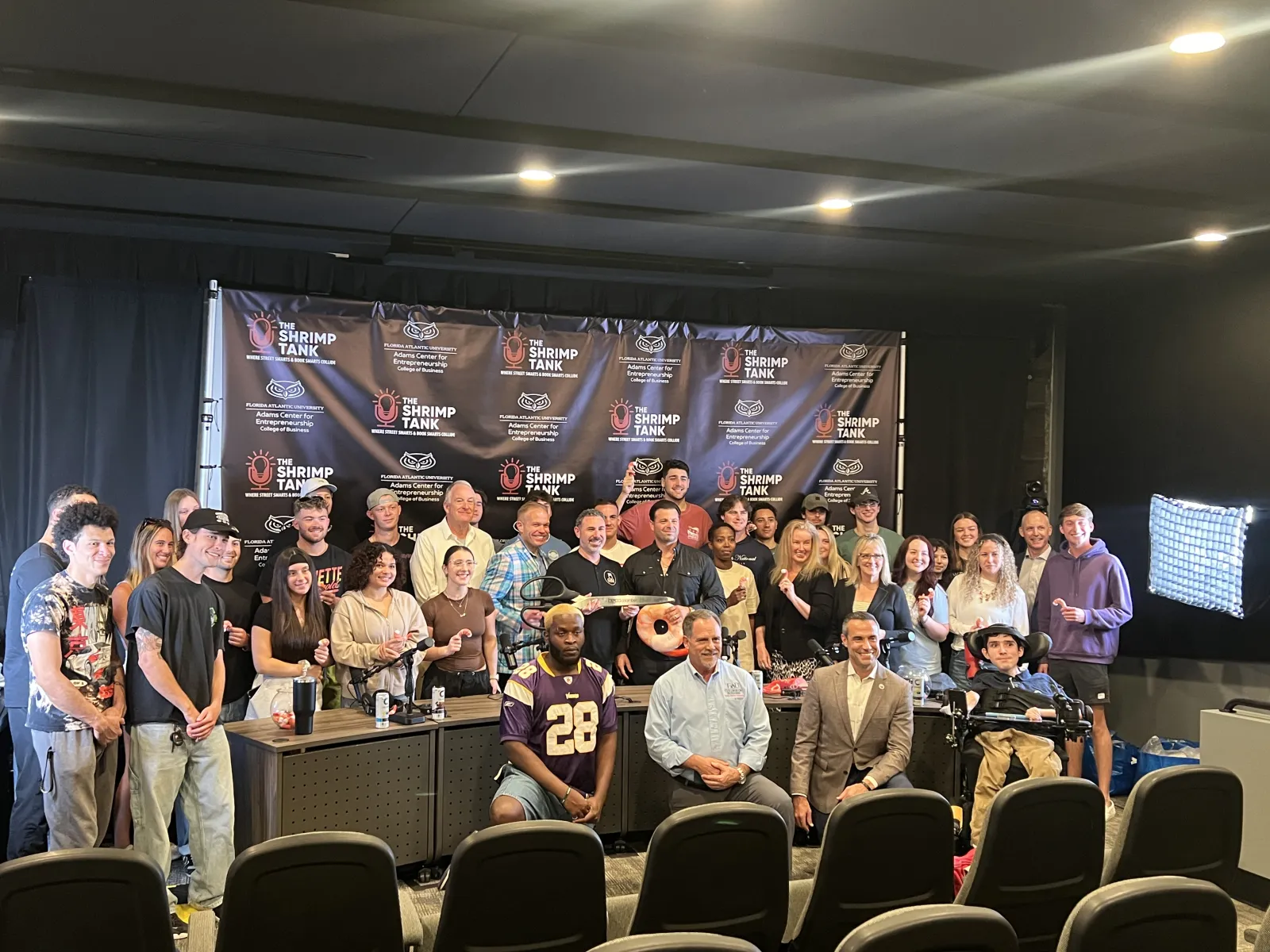 a group of people posing for a photo in front of a screen