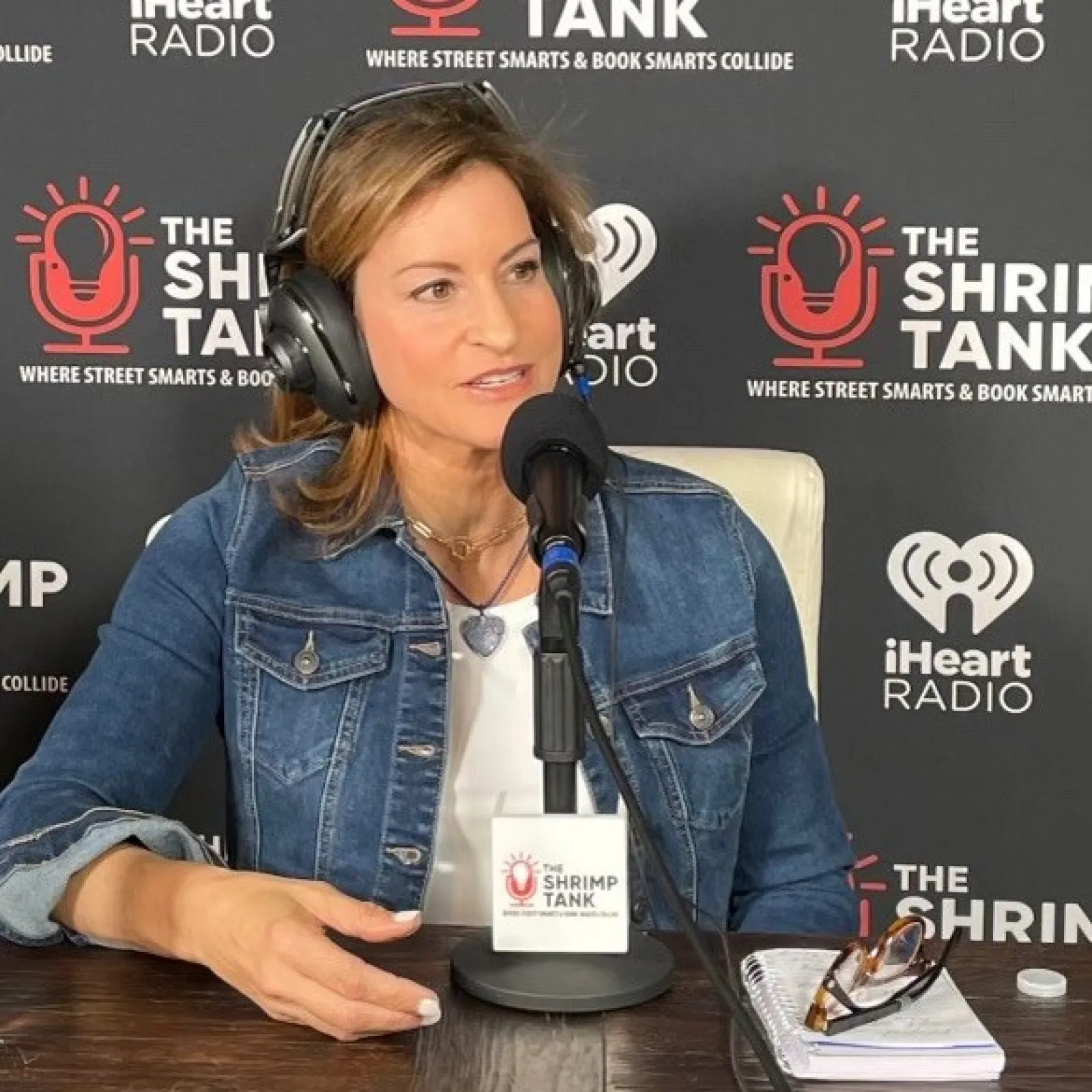 a person sitting at a table with a microphone and a bottle of water