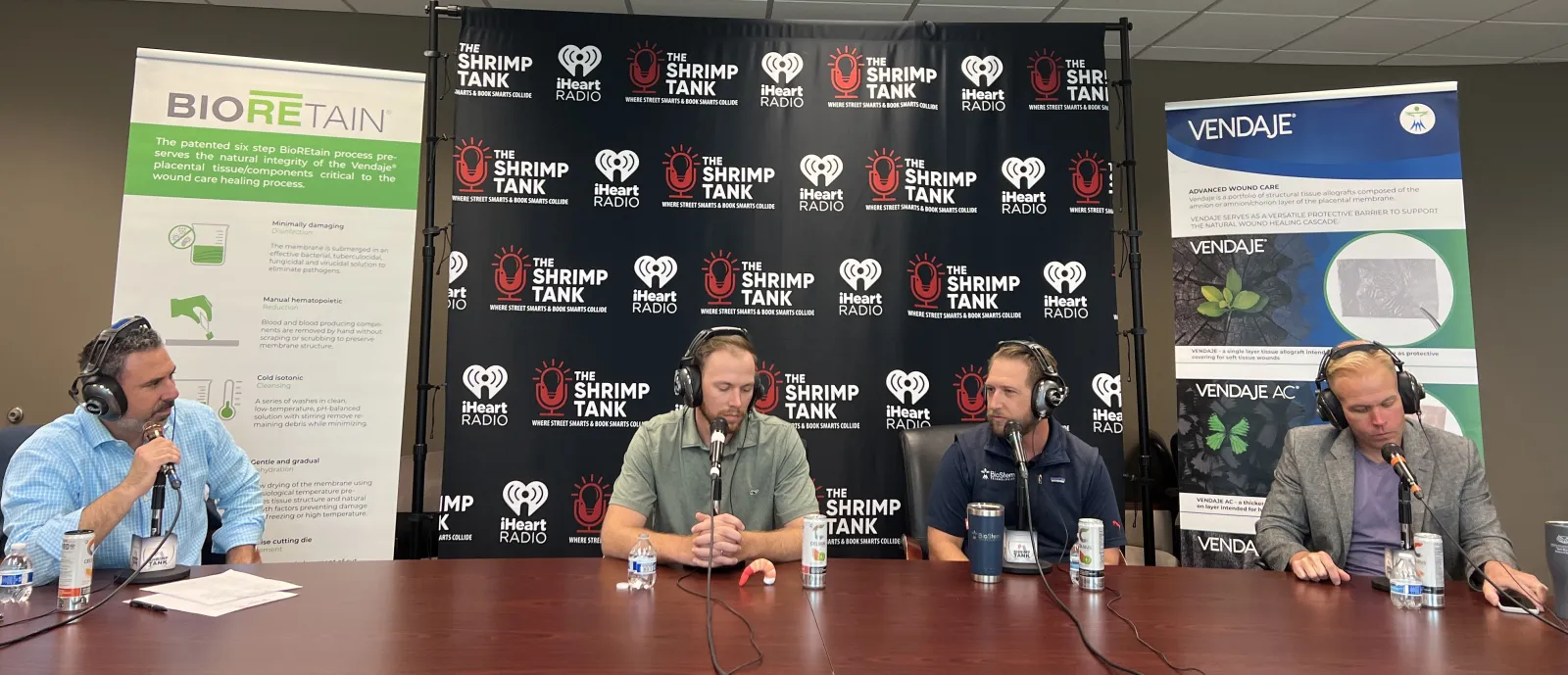 a group of people sitting at a table with microphones