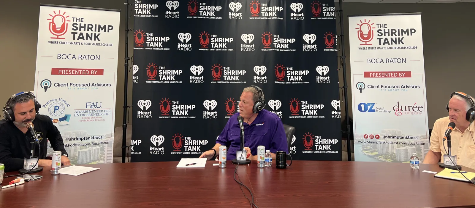 a group of people sitting at a table with microphones