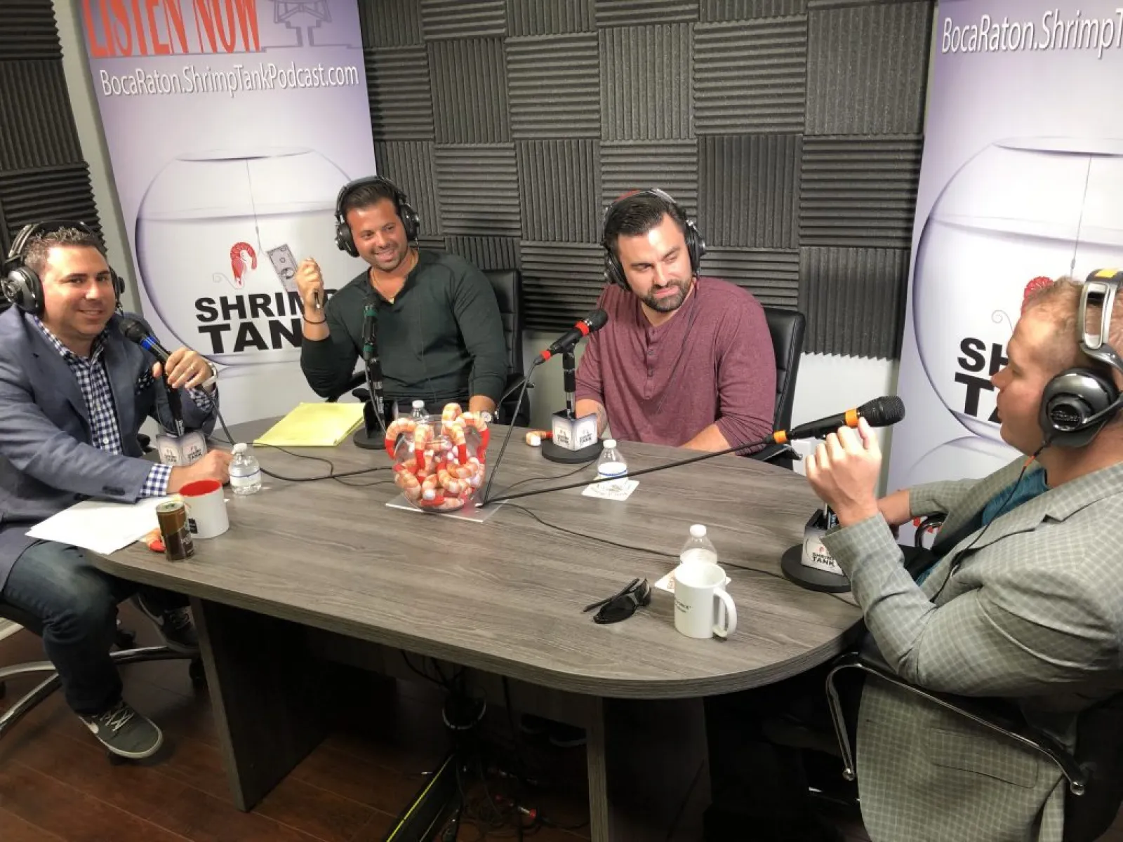 a group of men sitting around a table with microphones