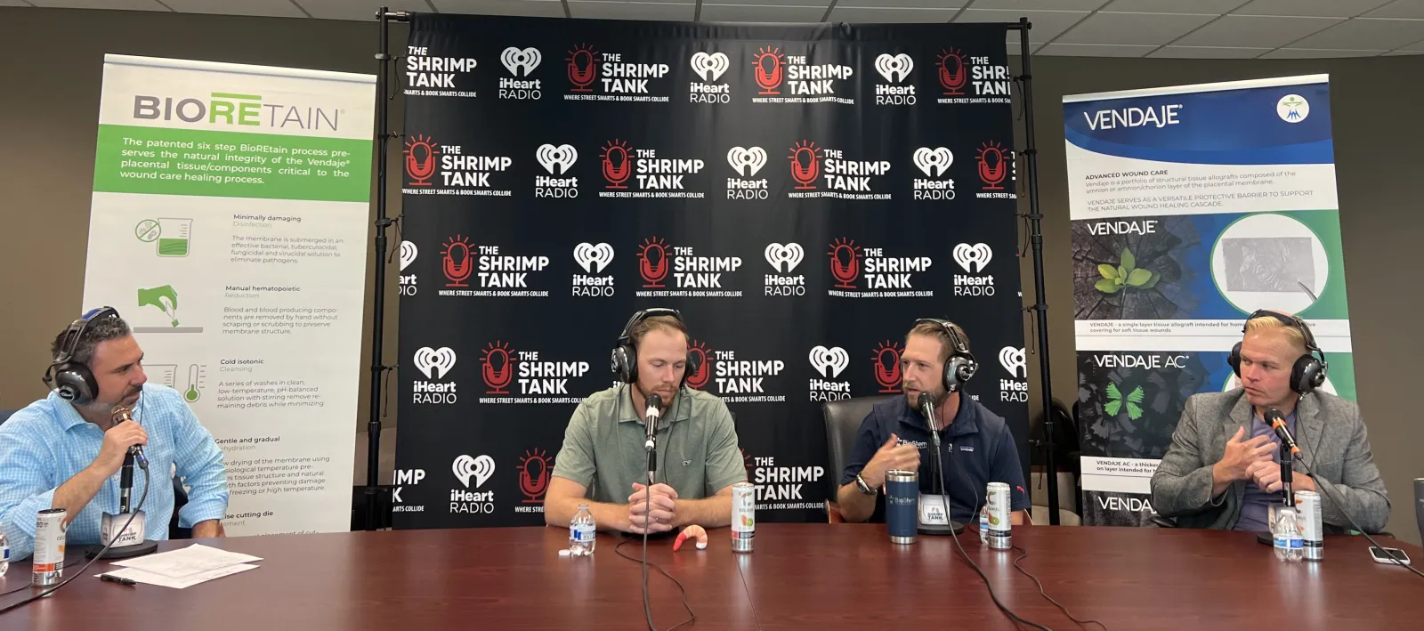 a group of people sitting at a table with microphones