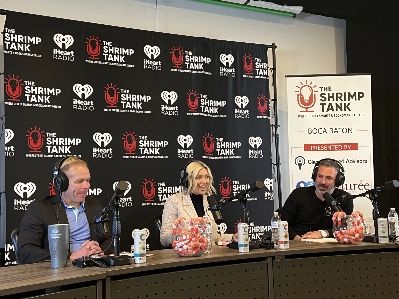 a group of people sitting at a table with microphones