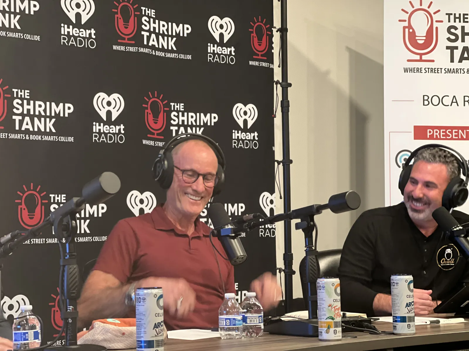 a couple of men sitting at a table with microphones