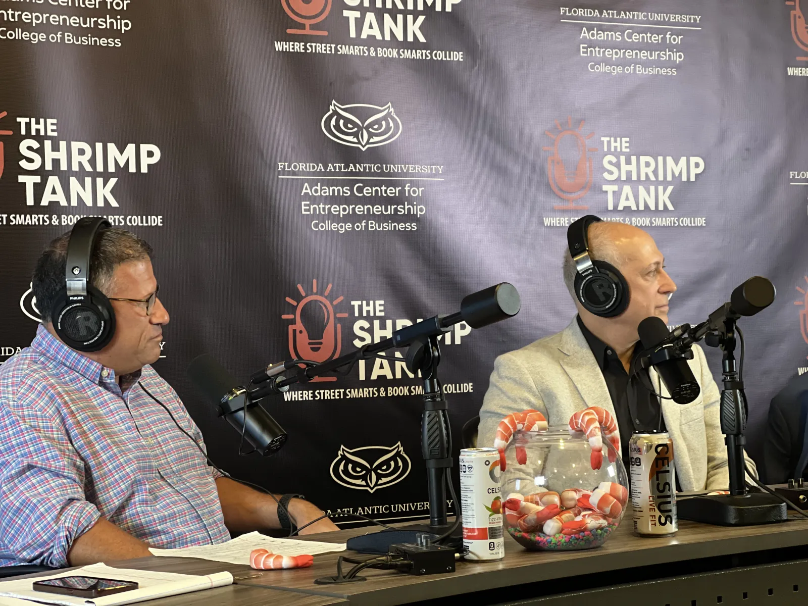 Two men wearing headphones speaking into microphones during The Shrimp Tank podcast at Florida Atlantic University.
