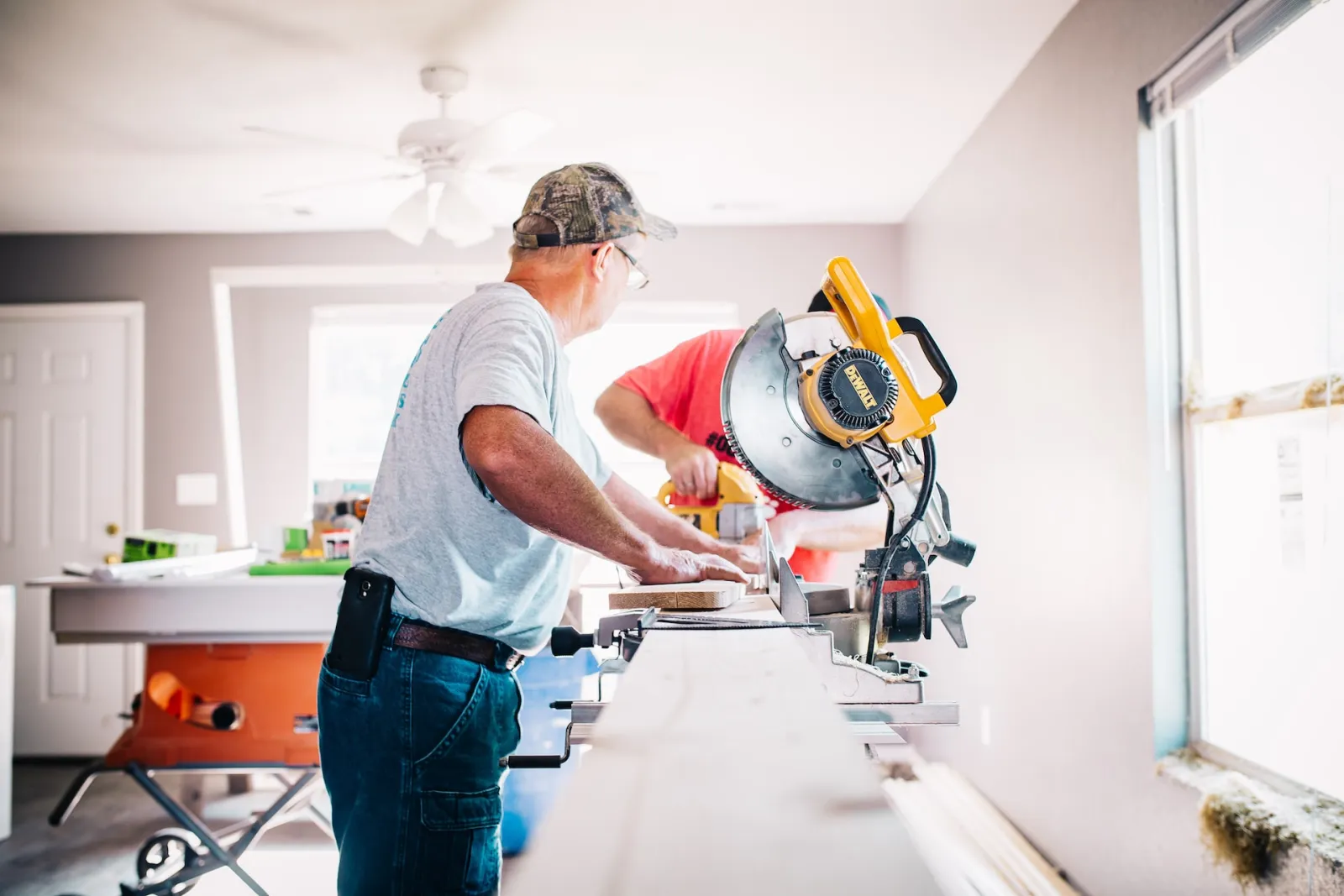 construction workers with a saw cutting wood for improvement project