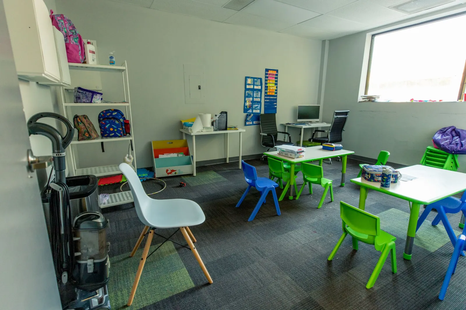 a room with green chairs and tables