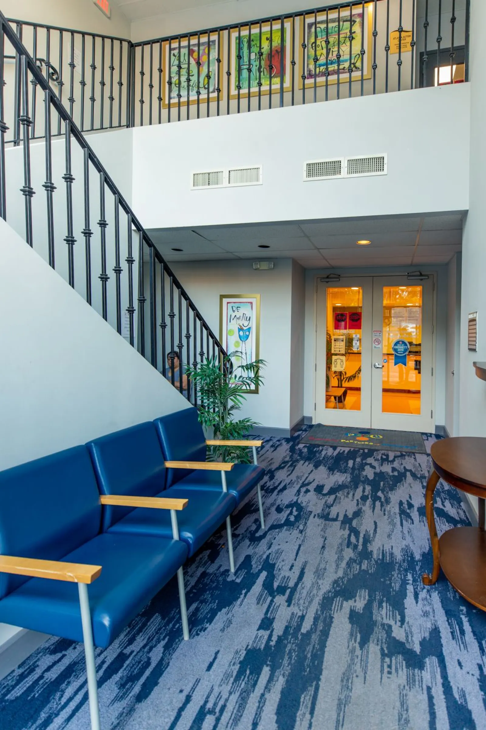 a room with blue chairs and a staircase