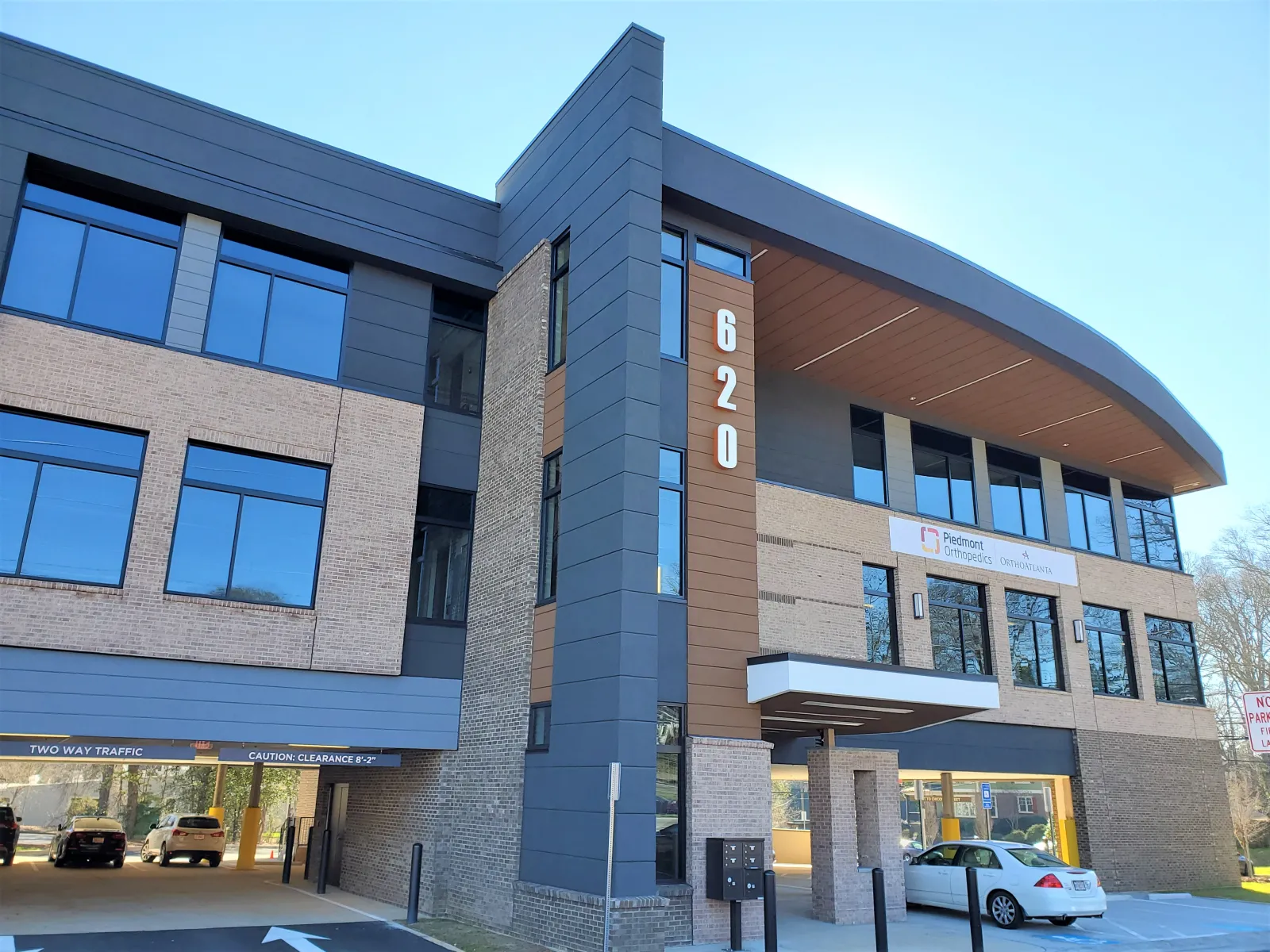 Modern three-story office building with brick and dark panel exterior and large reflective windows at 620 address.
