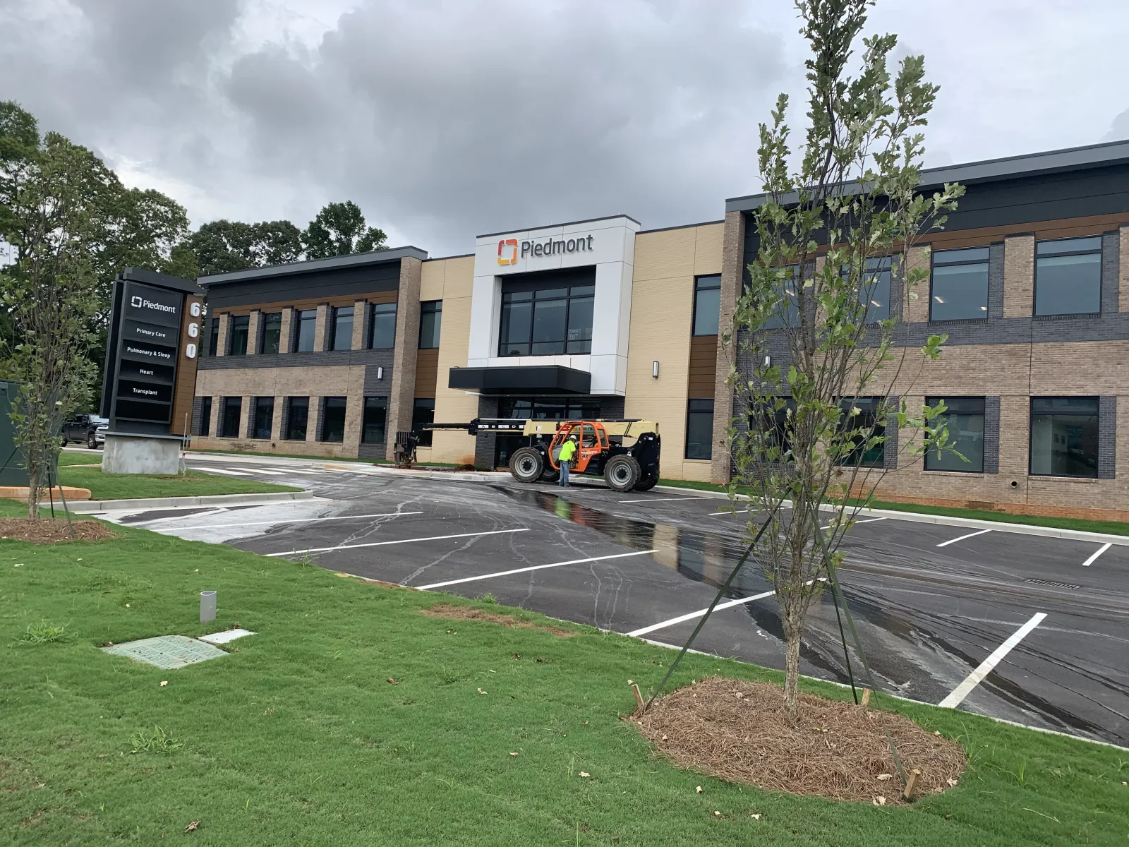Piedmont medical office building with parking lot, new landscaping, and cloudy sky.