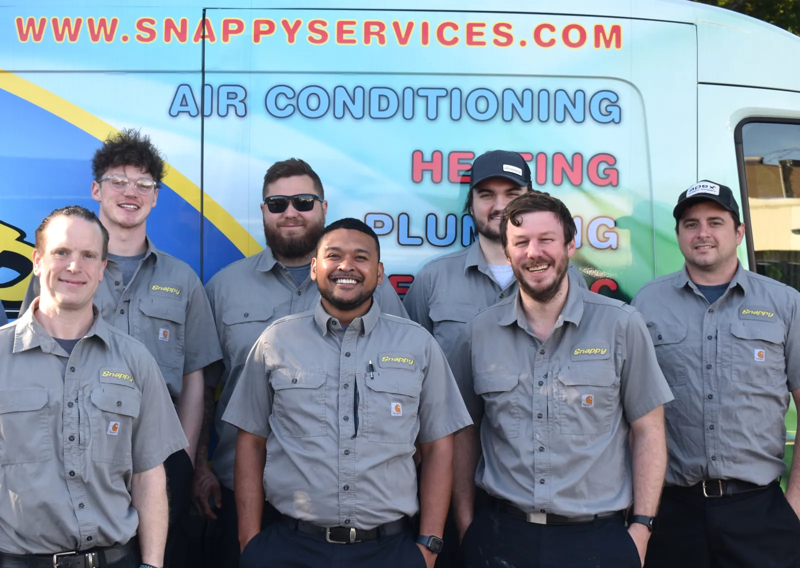 group of plumbers in front of a truck
