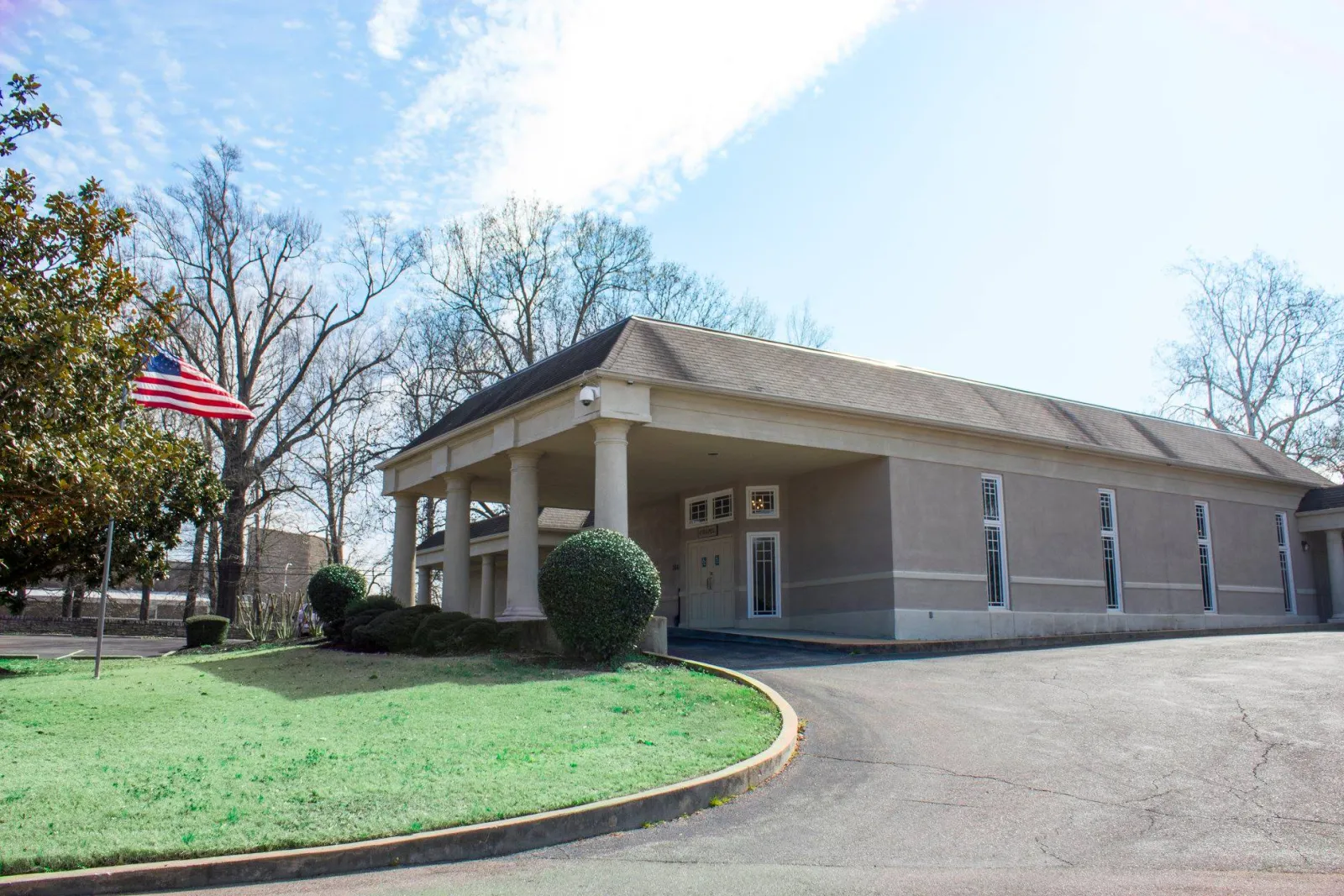 a large brick building with grass in front of a house