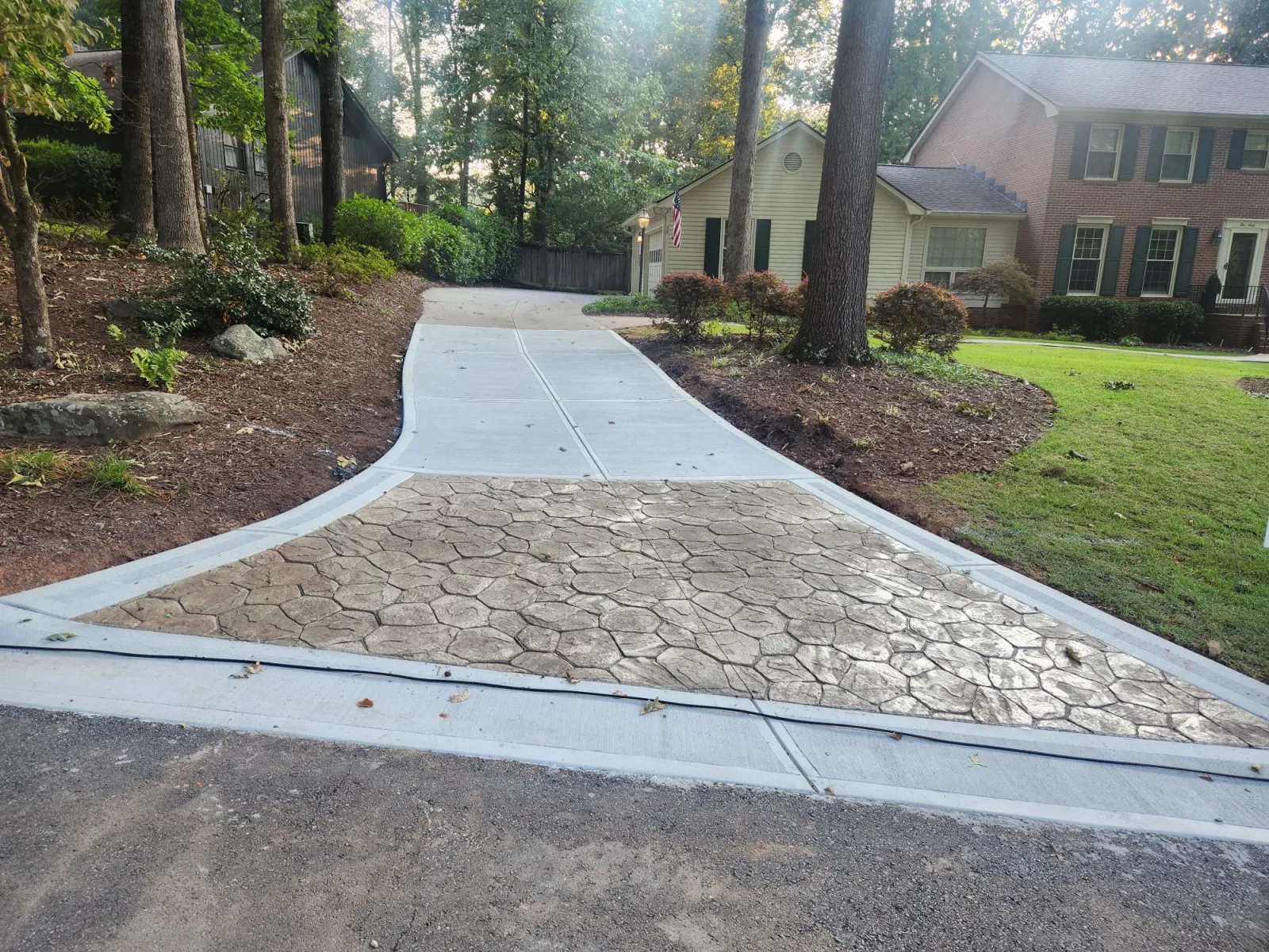 a stone walkway with grass and trees