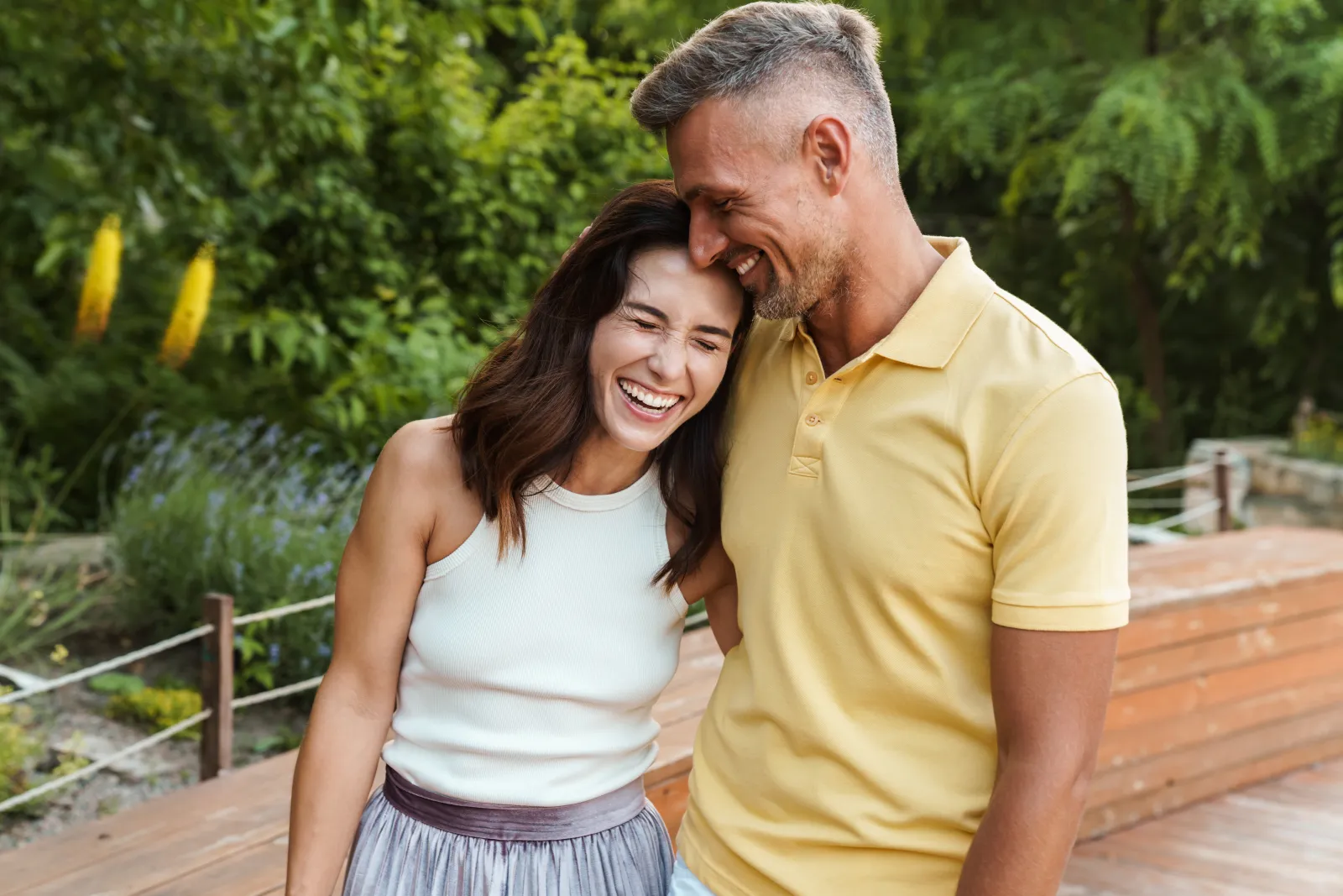 Healthy couple holding each other outdoors as they laugh together