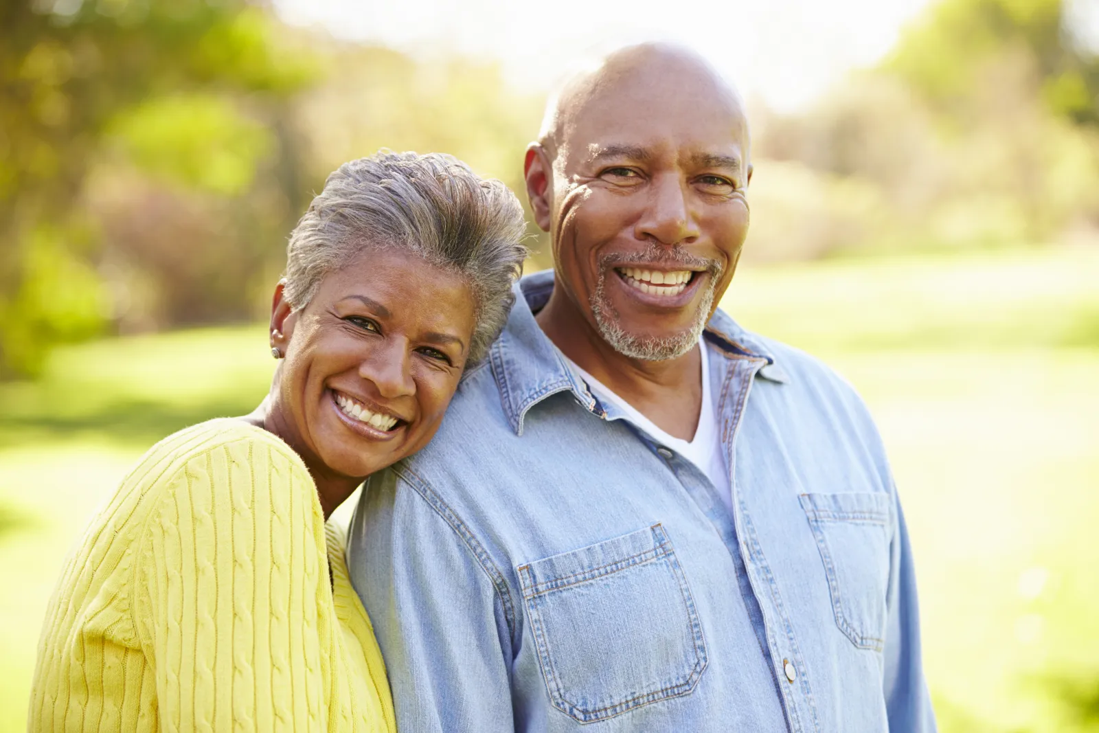 Happy older couple with good cardiovascular health holding each other outdoors