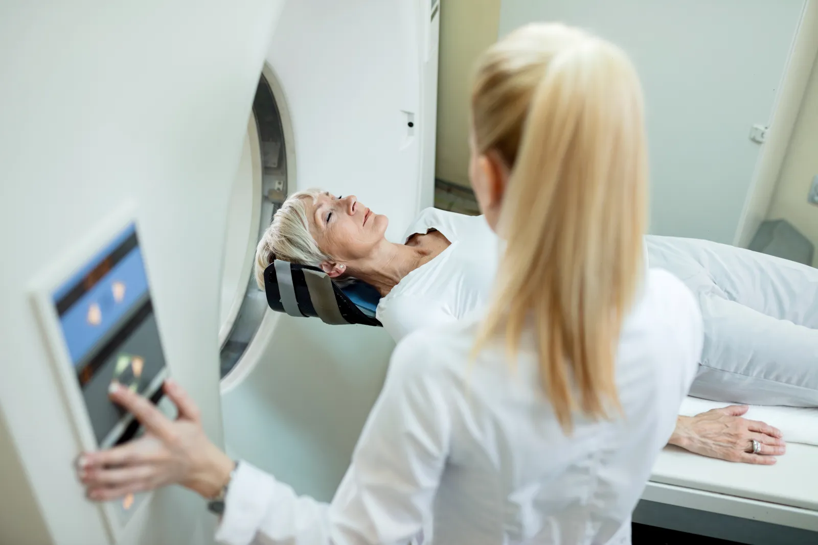 Doctor watching as a patient enters an MRI machine to screen for lung cancer