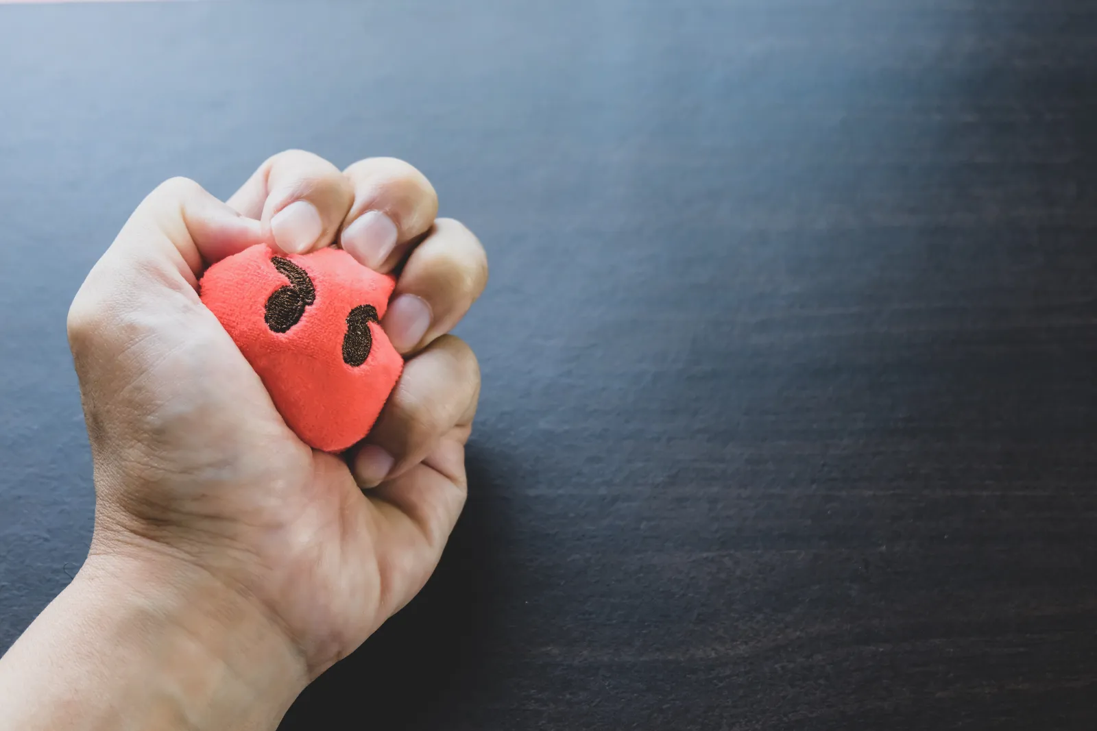 Close-up of a stressed person's hand squeezing a stress ball