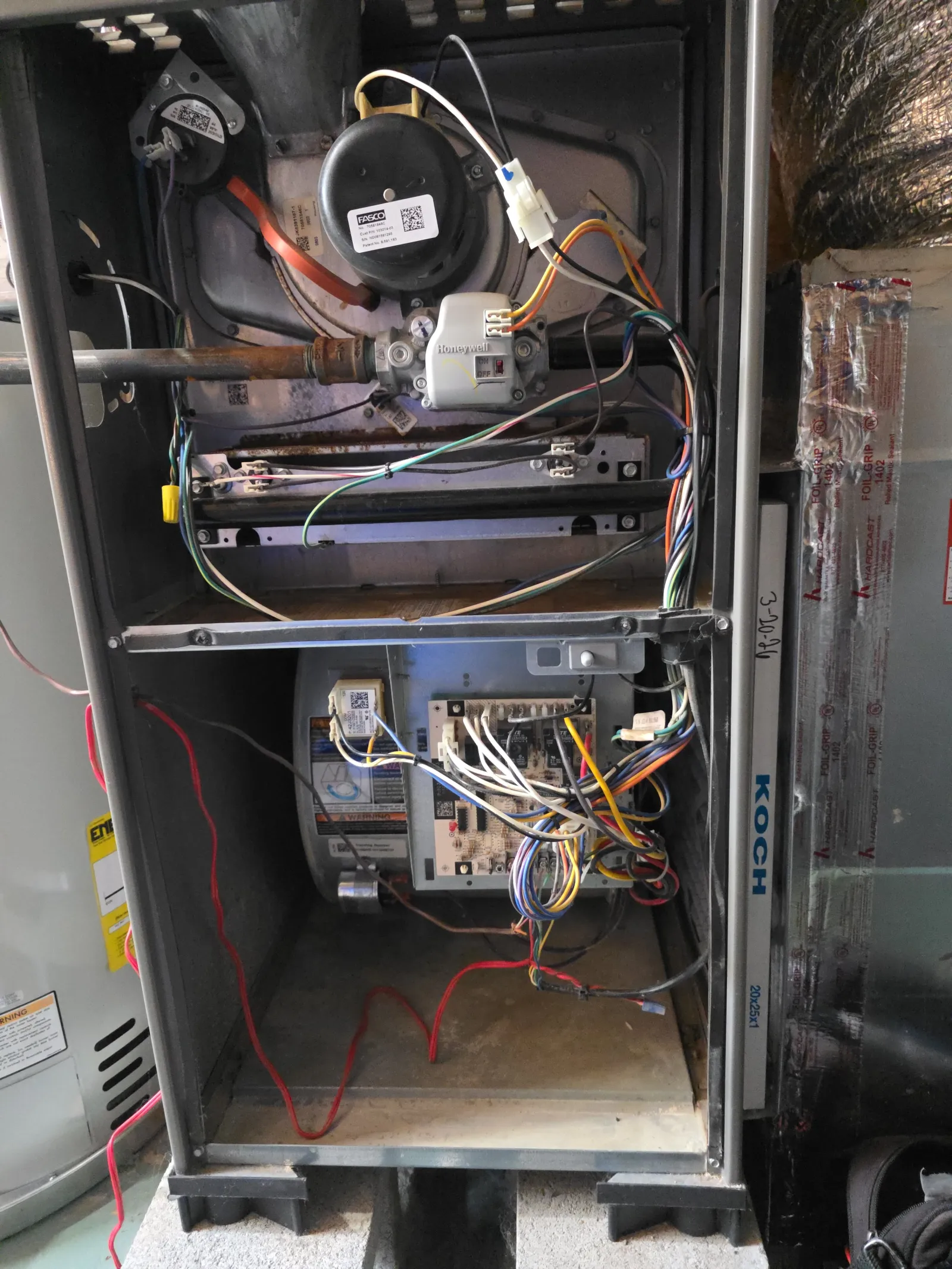 HVAC Repair, Maintenance and Installation in Roswell by The Air Company of GA. Open residential furnace showing internal wiring, circuit board, gas valve, and blower motor components inside metal casing.