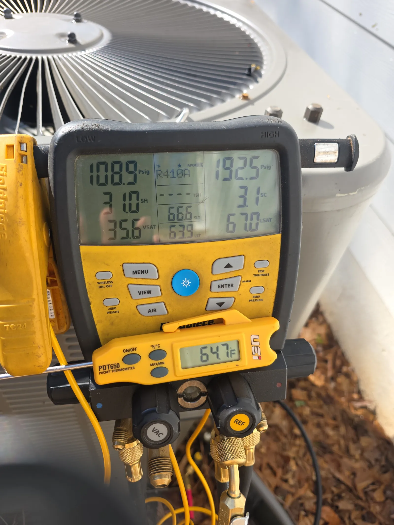 HVAC Repair, Maintenance and Installation in Roswell by The Air Company of GA. Digital HVAC gauge showing pressure and temperature readings on an air conditioning unit during maintenance.
