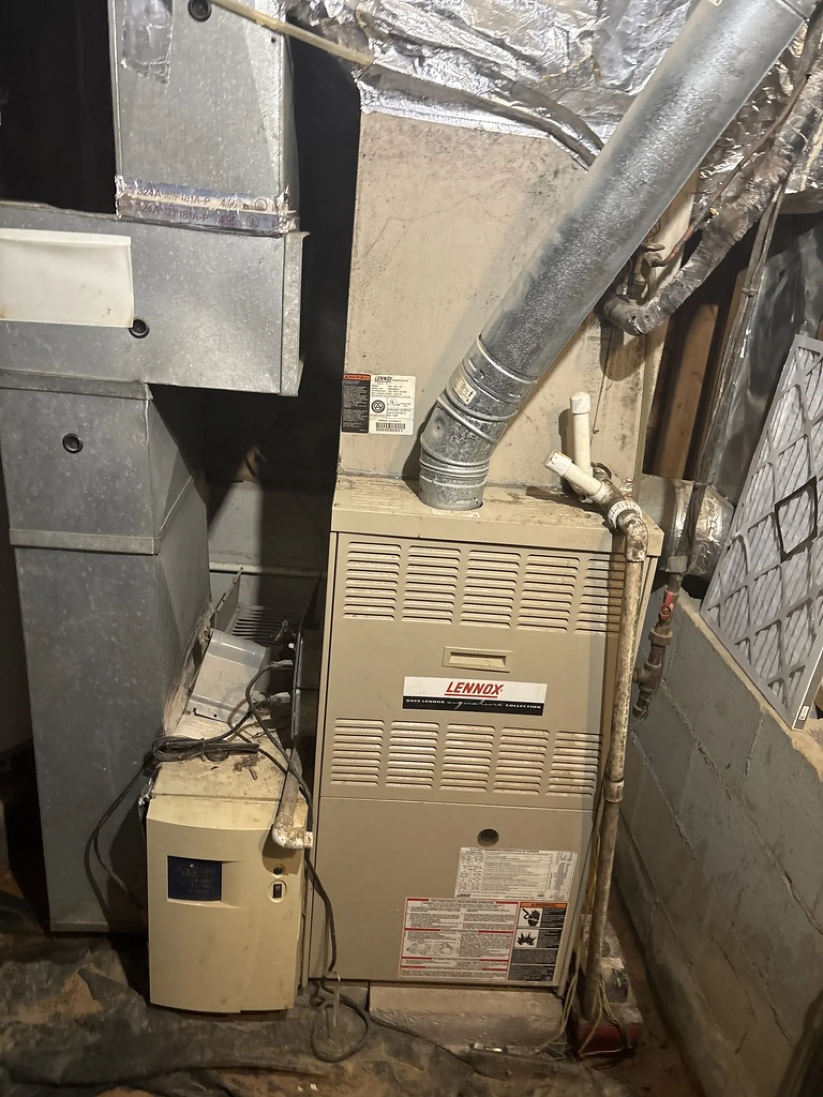 Lennox furnace and ductwork installed in a basement utility area with visible pipes and insulation.