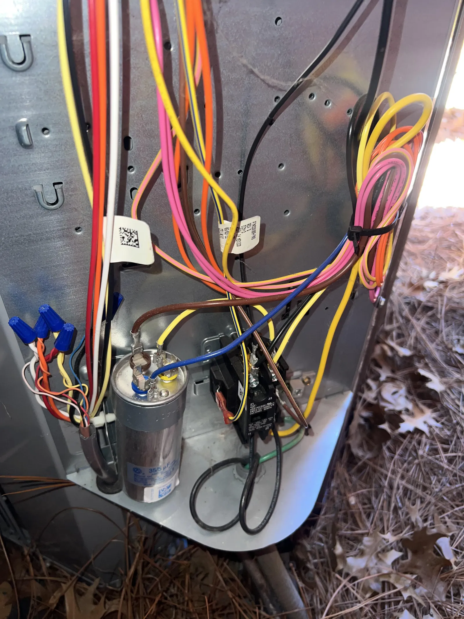 Atlanta AC Cooling Air Conditioner Repair in Vinnings 30339 by The Air Company of GA. Close-up of an HVAC unit's wiring and components including a capacitor and colored electrical cables inside metal casing.