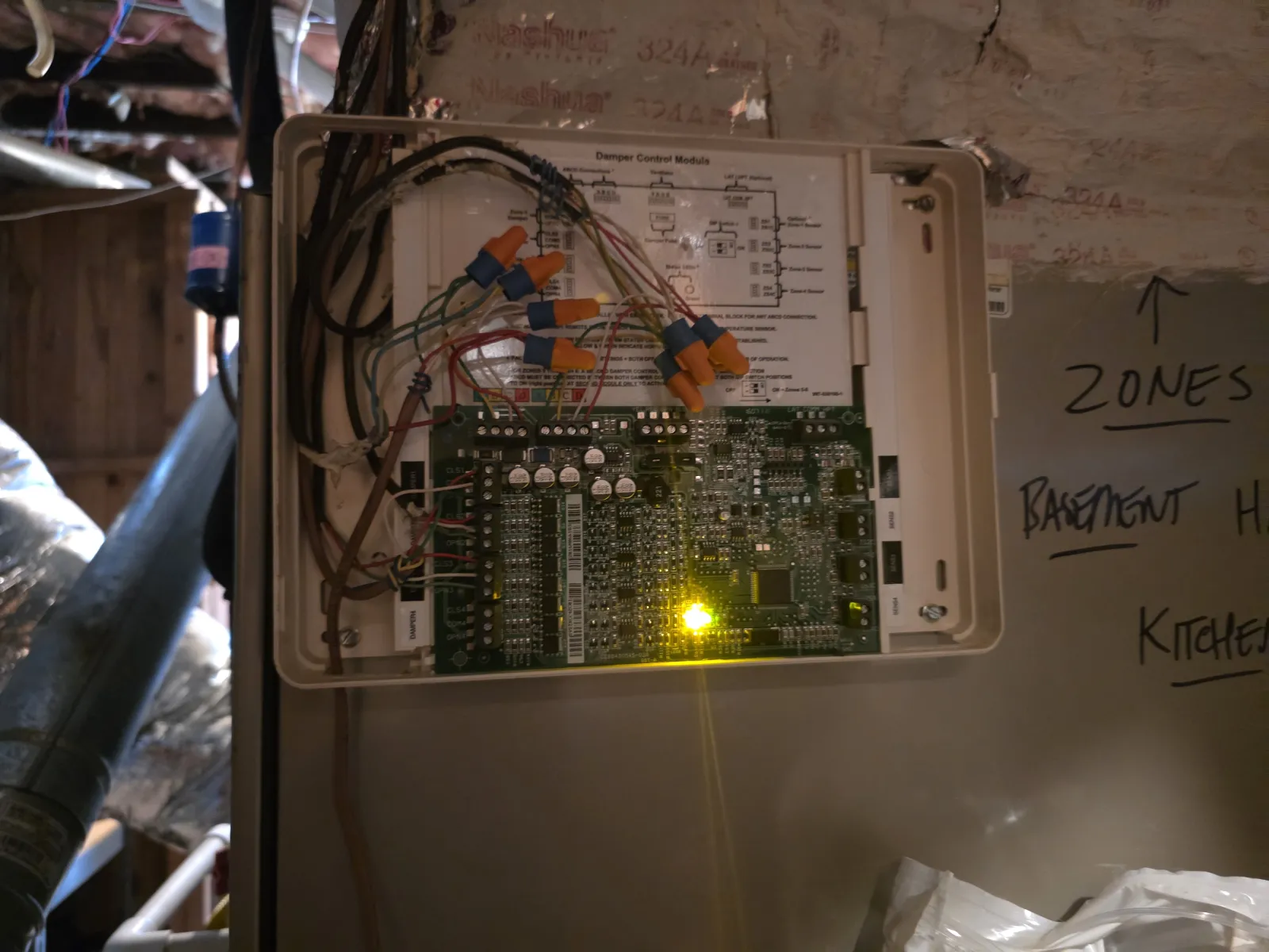 Open control panel showcasing complex wiring and electronic circuit board with glowing yellow indicator light
